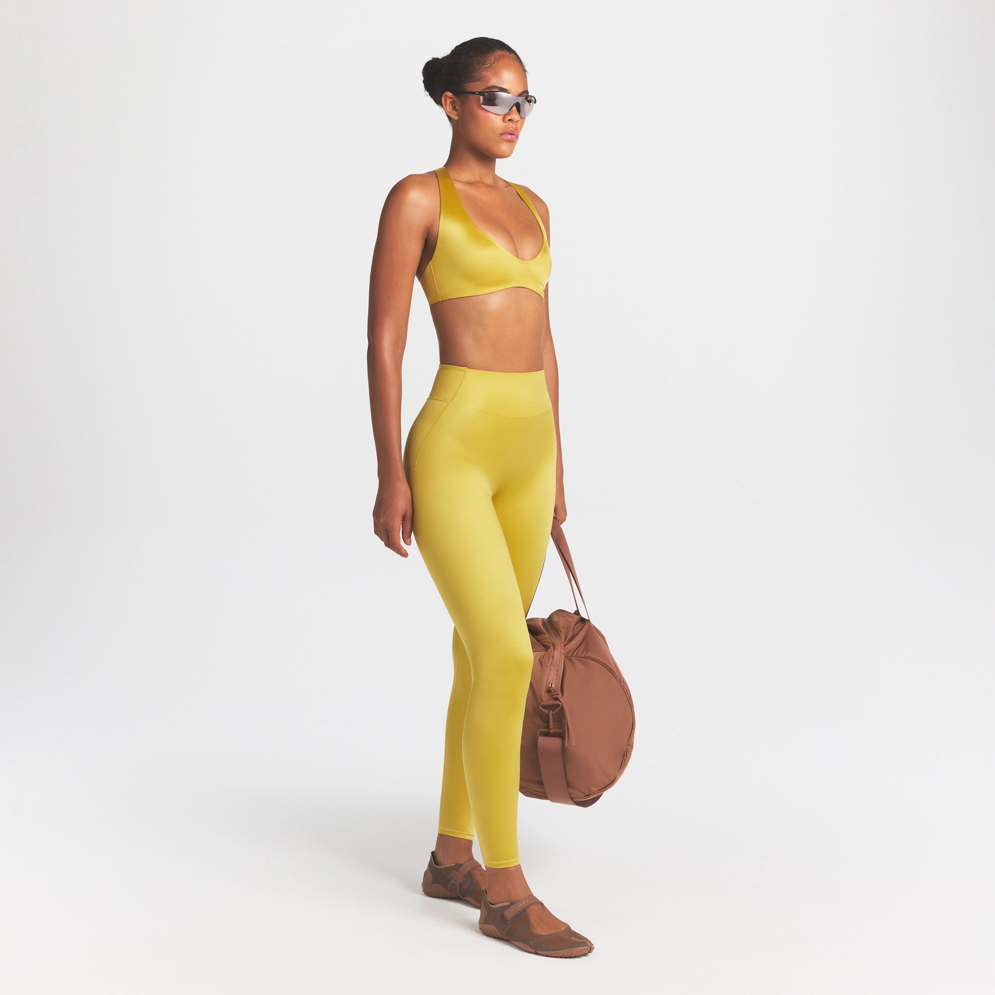 NikeSKIMS SATIN SHINE BONDED WAIST 26" LEGGING | CITRINE ON A MODEL FRONT VIEW @ | FOCUS: 0.0, 1.0, 0.9
