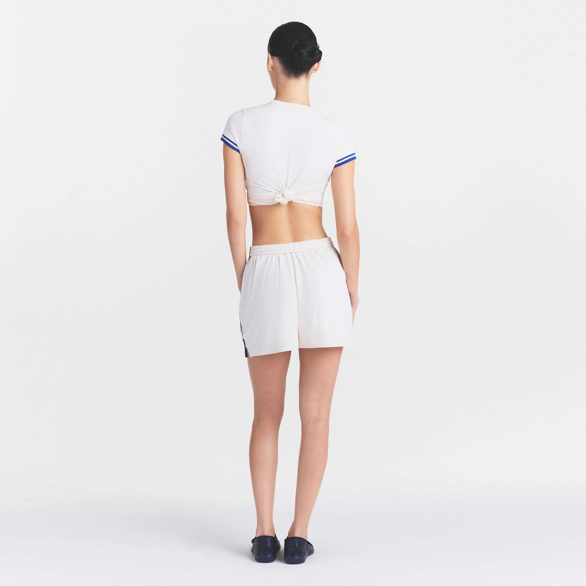 NikeSKIMS STRETCH KNIT DOLPHIN SHORT | IVORY ON A MODEL FRONT VIEW @ | FOCUS: 0.0, 1.0, 0.9