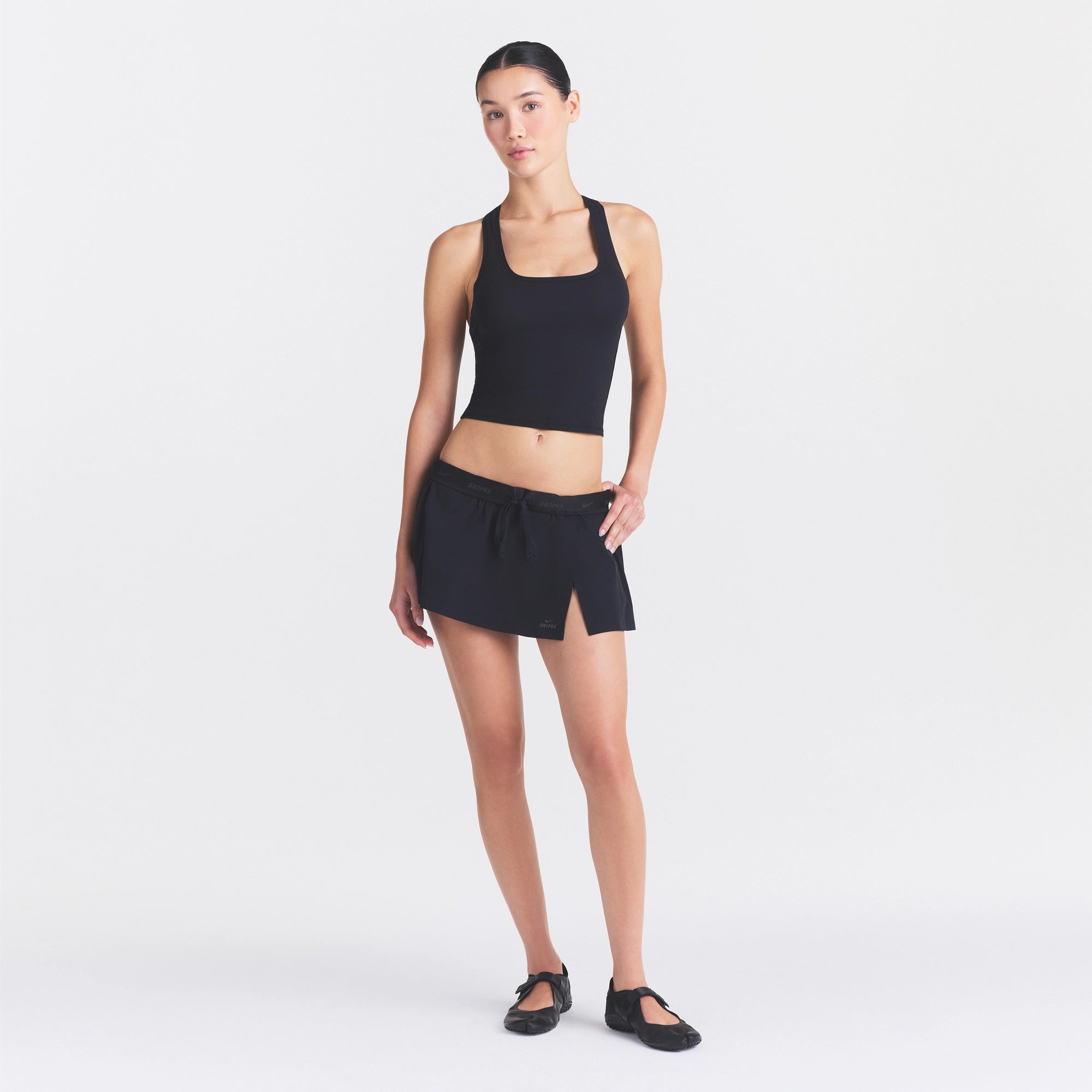 NikeSKIMS STRETCH NYLON SKORT | OBSIDIAN ON A MODEL FRONT VIEW @ | FOCUS: 0.0, 1.0, 0.9