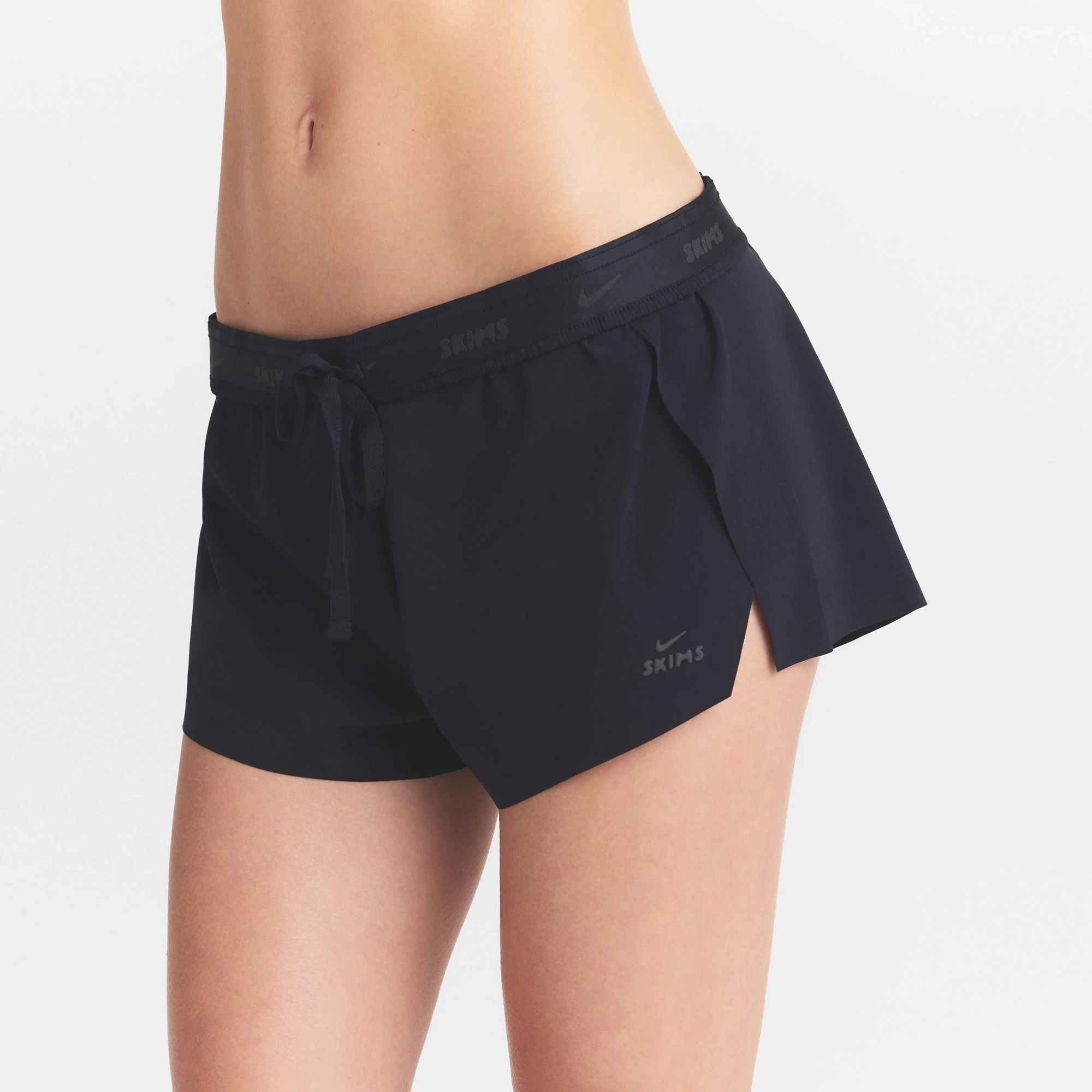 NikeSKIMS STRETCH NYLON RUNNER SHORT | OBSIDIAN ON A MODEL SIDE VIEW