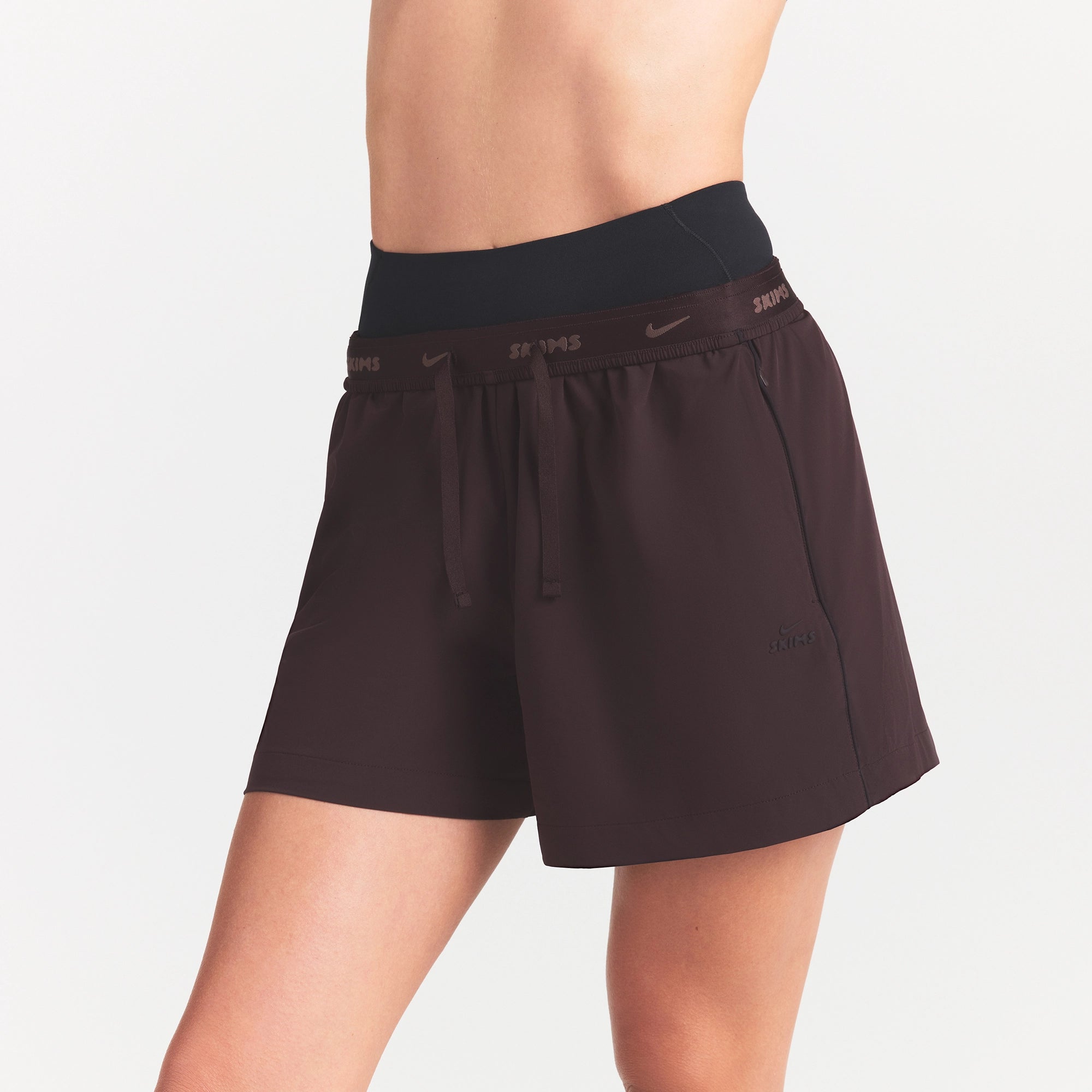 NikeSKIMS STRETCH NYLON 5" TRACK SHORT | DARK ROAST ON A MODEL SIDE VIEW @ | FOCUS: 0.0, 1.0, 0.9