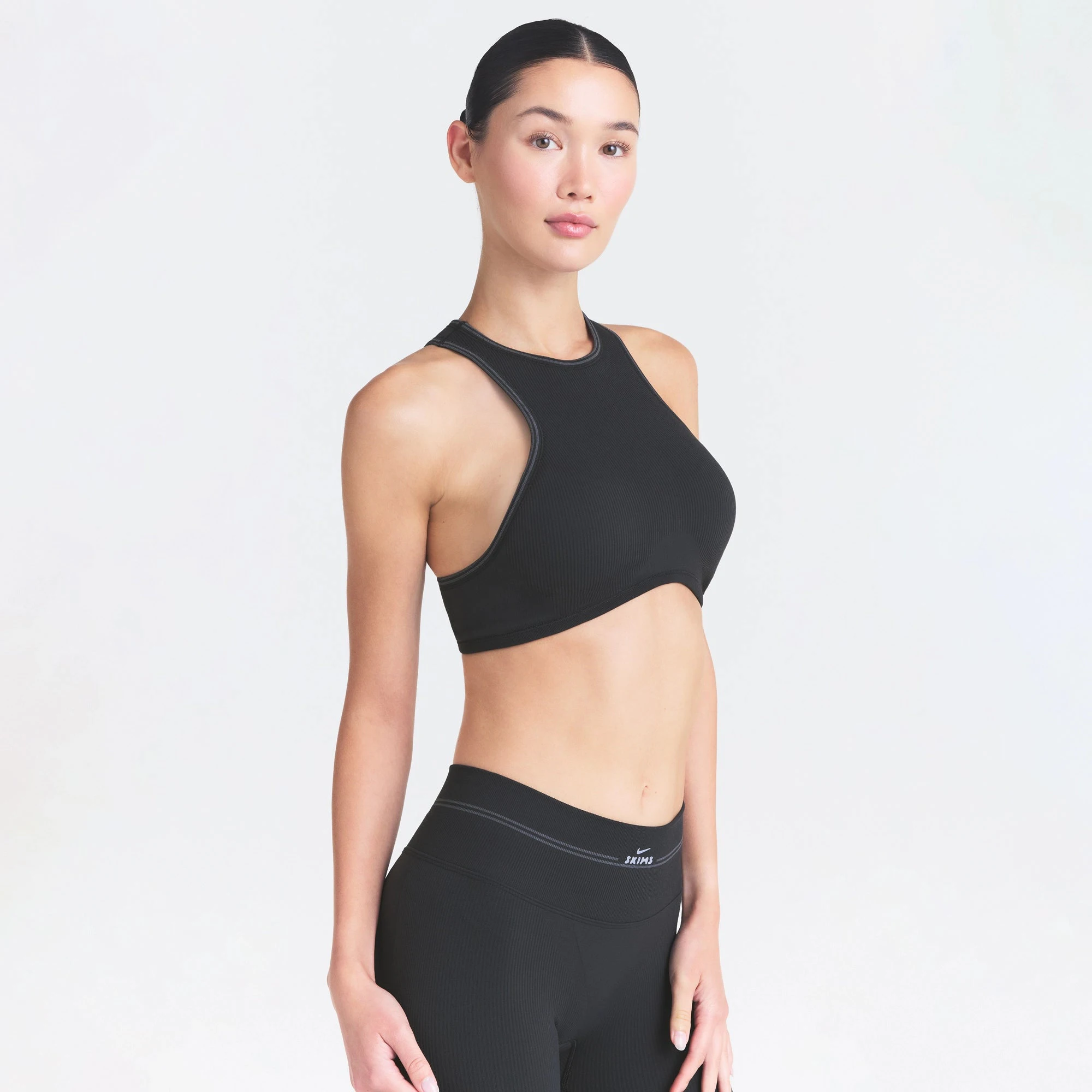 NikeSKIMS RIBBED SEAMLESS RACER FRONT BRA | OBSIDIAN ON A MODEL SIDE VIEW