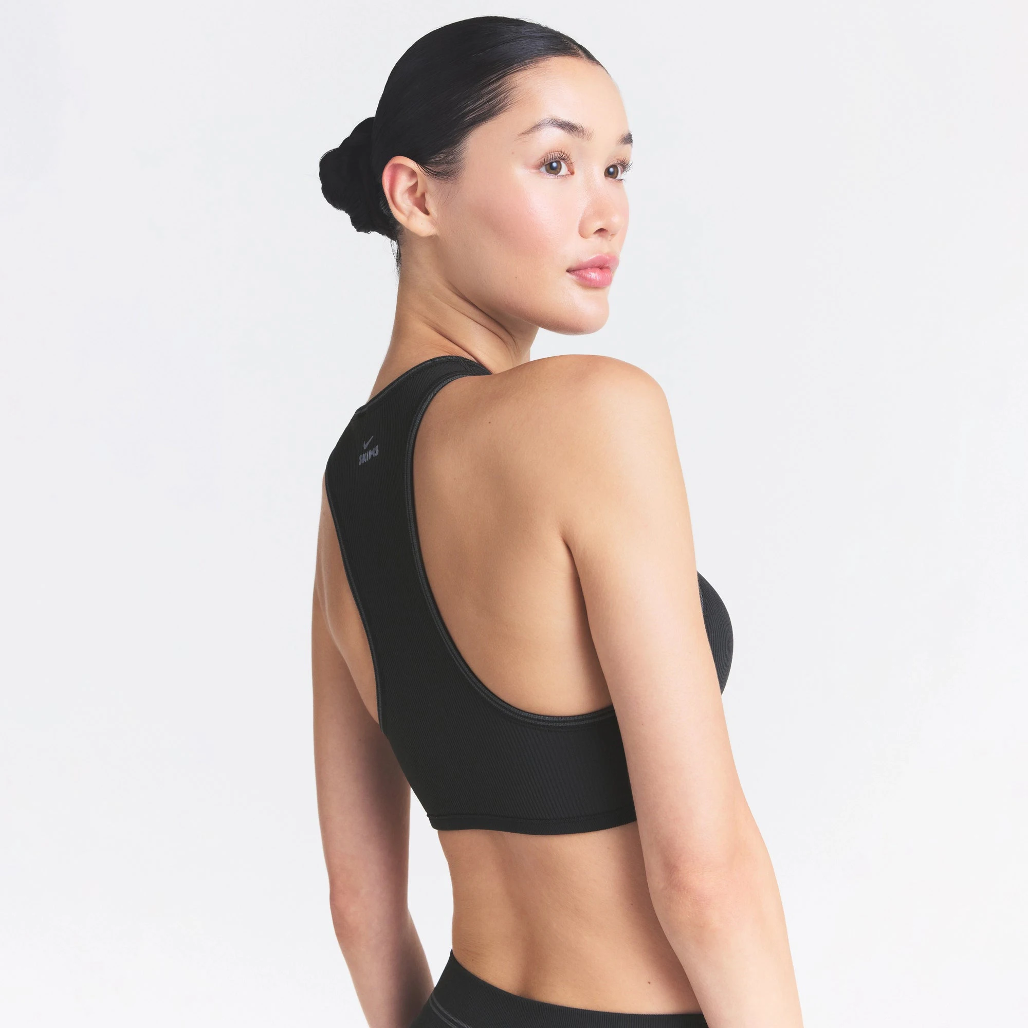 NikeSKIMS RIBBED SEAMLESS RACER FRONT BRA | OBSIDIAN ON A MODEL SIDE VIEW