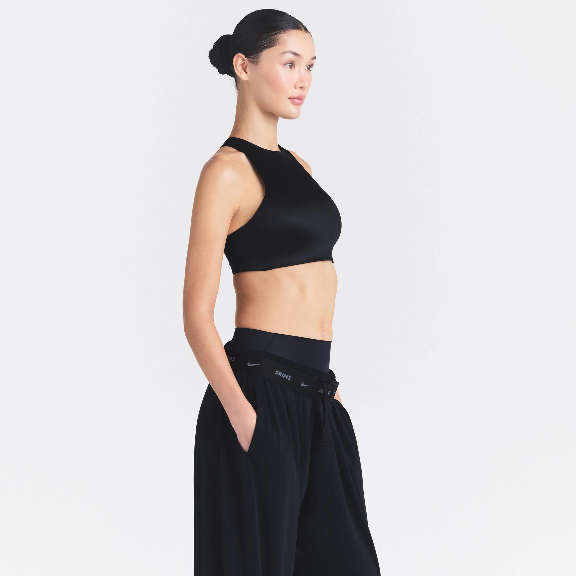 NikeSKIMS SATIN SHINE HIGH NECK BRA | OBSIDIAN ON A MODEL SIDE VIEW @ | FOCUS: 0.0, 1.0, 0.9