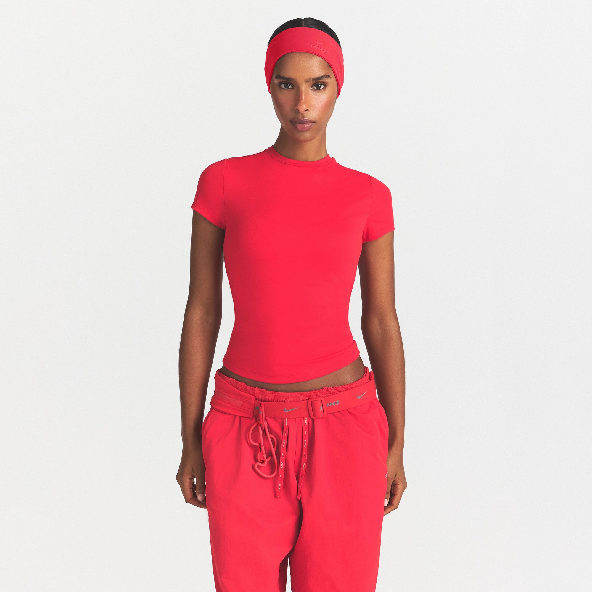 NikeSKIMS MATTE PADDED BABY TEE | UNIVERSITY RED ON A MODEL SIDE VIEW @ | FOCUS: 0.0, 1.0, 0.9