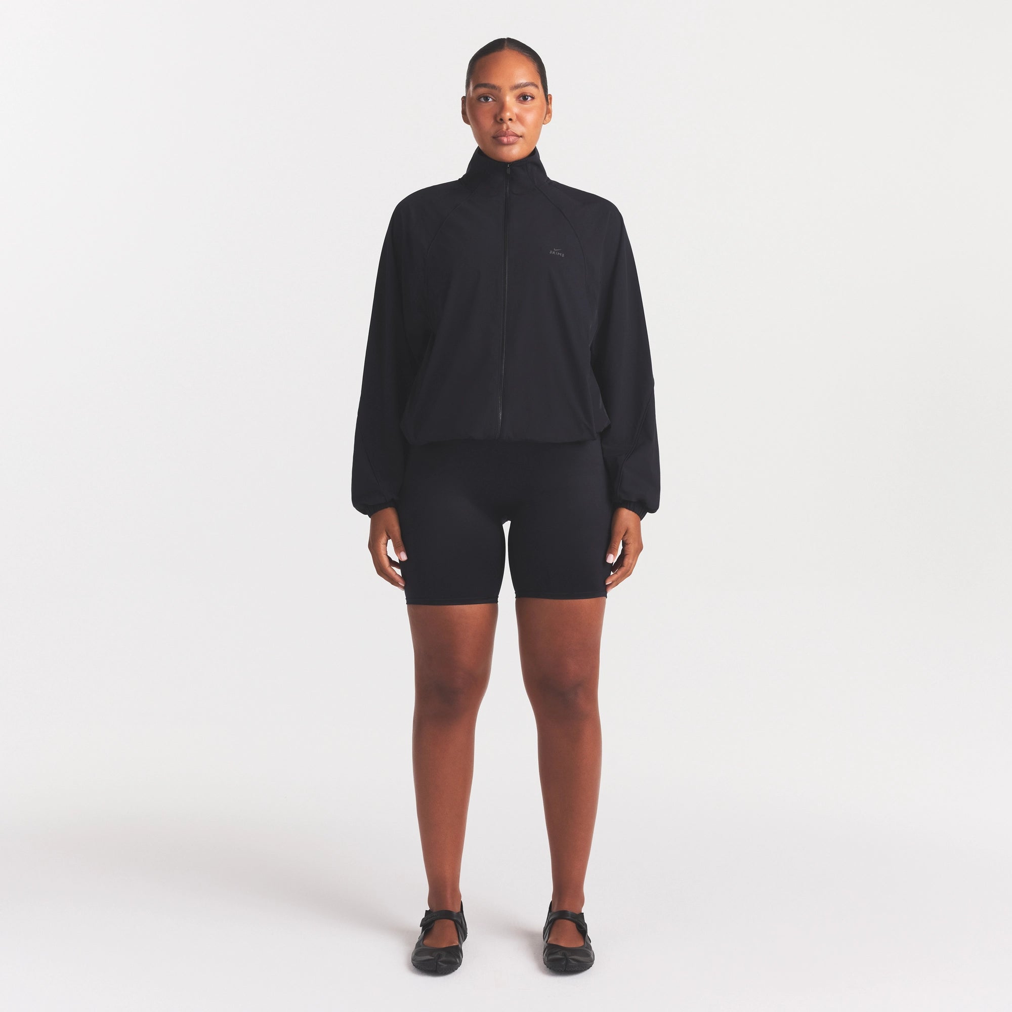 NikeSKIMS STRETCH NYLON OVERSIZED TRACK JACKET | OBSIDIAN ON A MODEL FRONT VIEW
