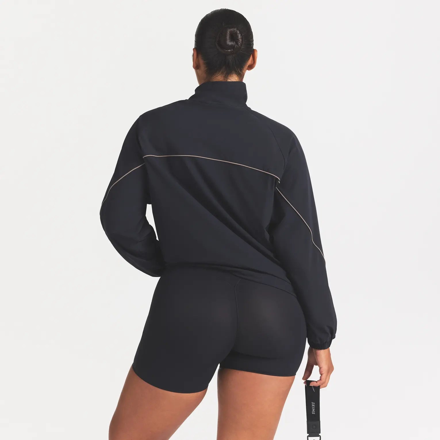 NikeSKIMS STRETCH NYLON OVERSIZED TRACK JACKET | OBSIDIAN ON A MODEL SIDE VIEW