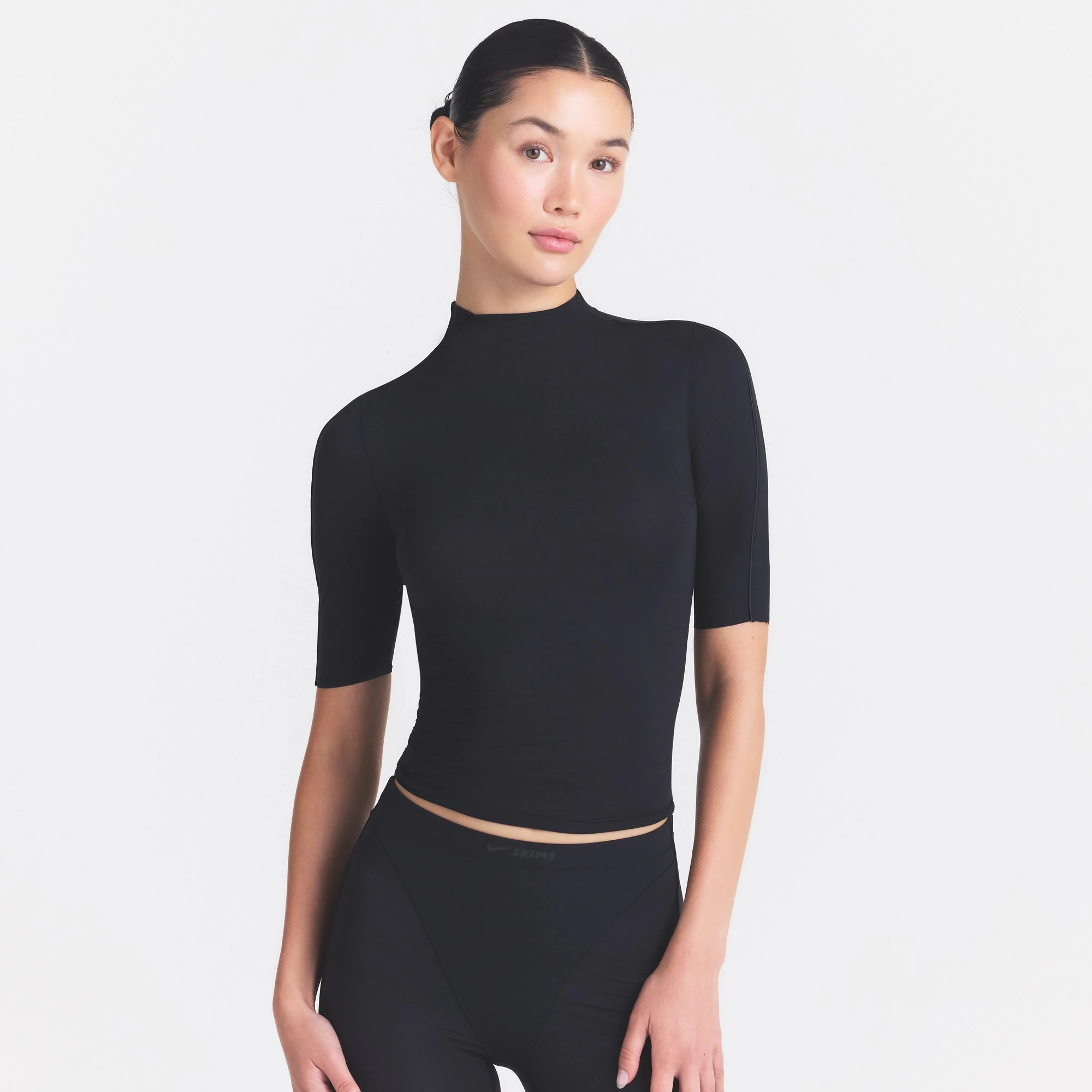 NikeSKIMS WEIGHTLESS LAYERS MOCK NECK SHORT SLEEVE T-SHIRT | OBSIDIAN ON A MODEL SIDE VIEW @ | FOCUS: 0.0, 1.0, 0.9