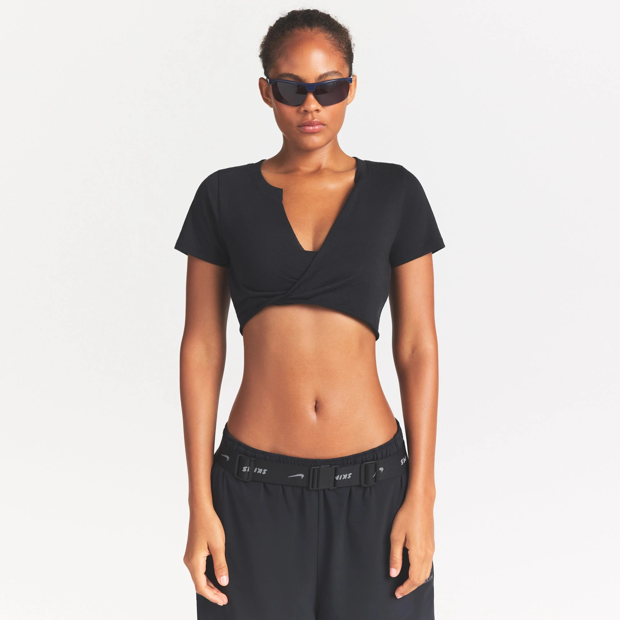 NikeSKIMS PERFORMANCE COTTON BLEND SHORT SLEEVE V-NECK TOP | OBSIDIAN ON A MODEL SIDE VIEW @ | FOCUS: 0.0, 1.0, 0.9