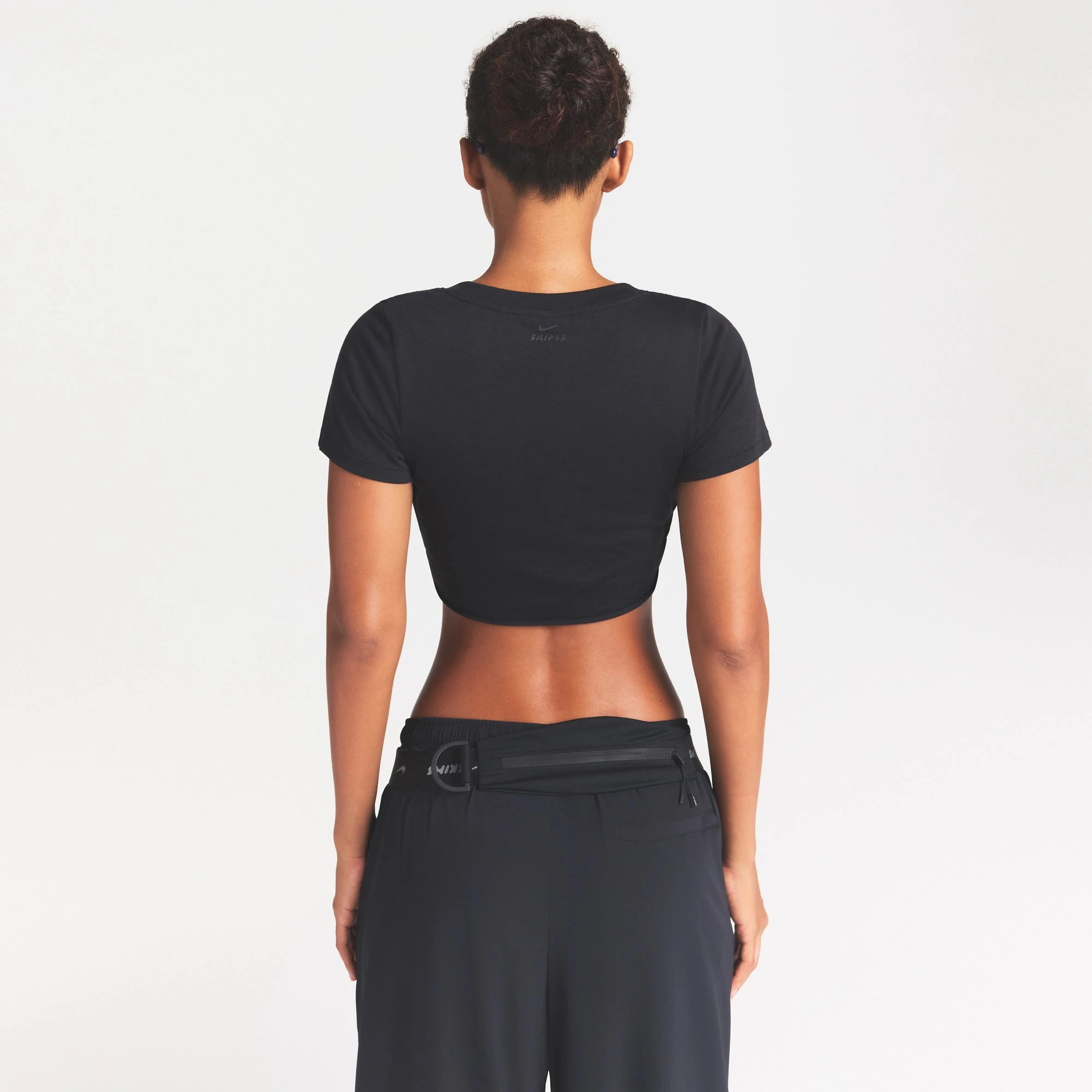 NikeSKIMS PERFORMANCE COTTON BLEND CROP TWIST TANK | OBSIDIAN ON A MODEL SIDE VIEW @ | FOCUS: 0.0, 1.0, 0.9