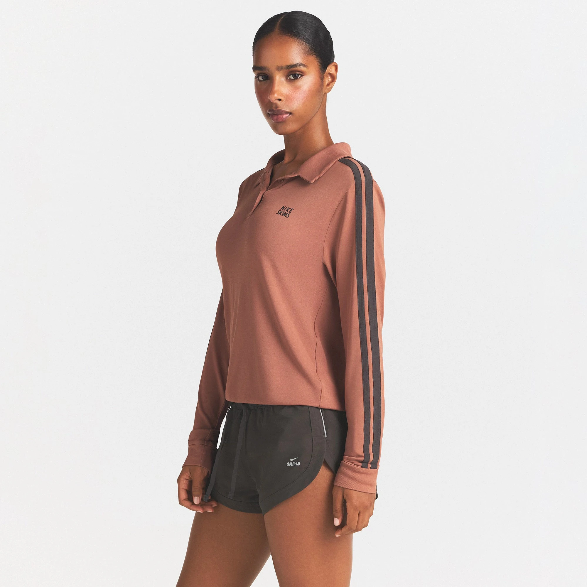 NikeSKIMS STRETCH KNIT LONG SLEEVE POLO TOP | CAROB BROWN/BOULDER ON A MODEL SIDE VIEW @ | FOCUS: 0.0, 1.0, 0.9