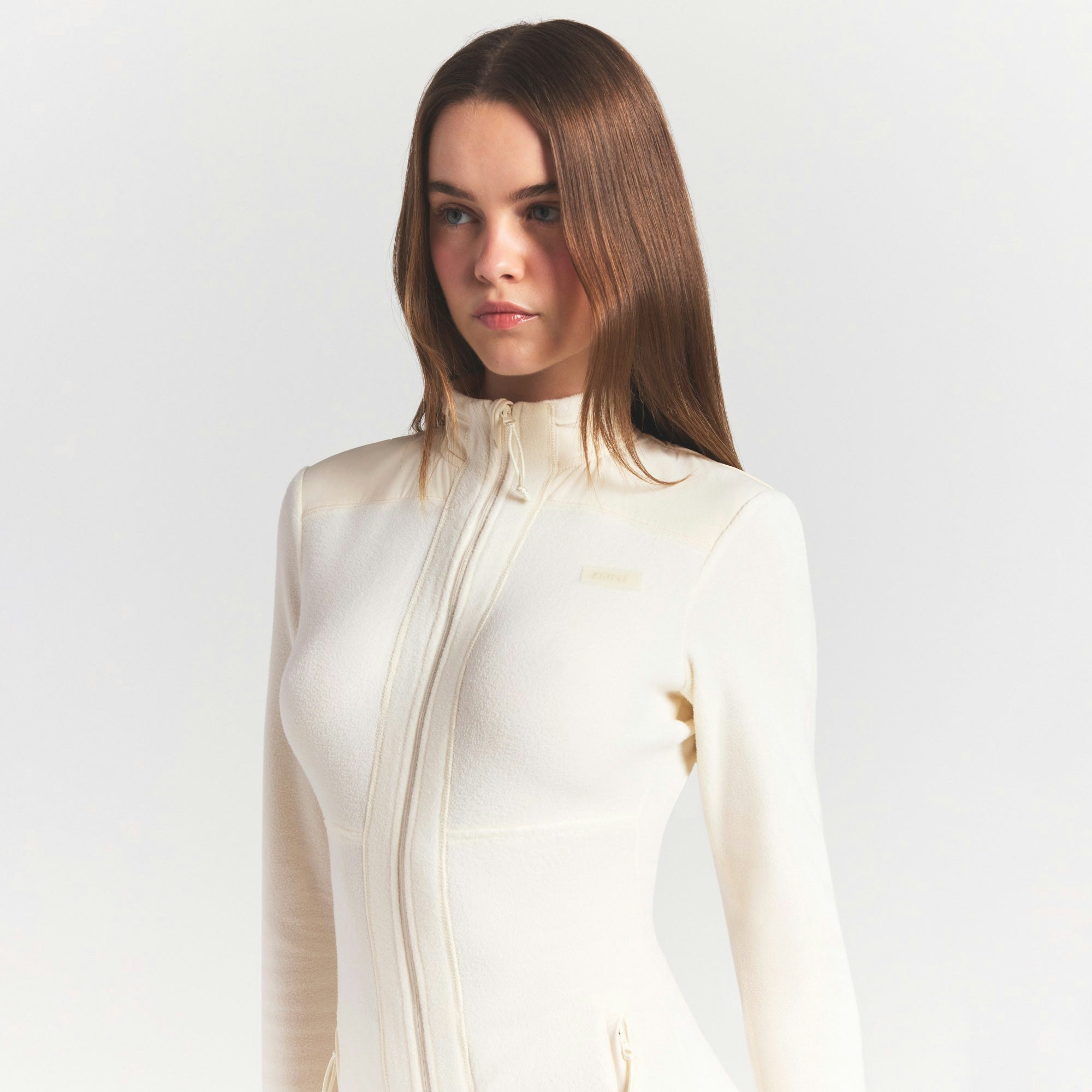 OUTDOOR FLEECE CATSUIT | ECRU ON A MODEL SIDE VIEW @ | FOCUS: 0.0, 1.0, 0.9