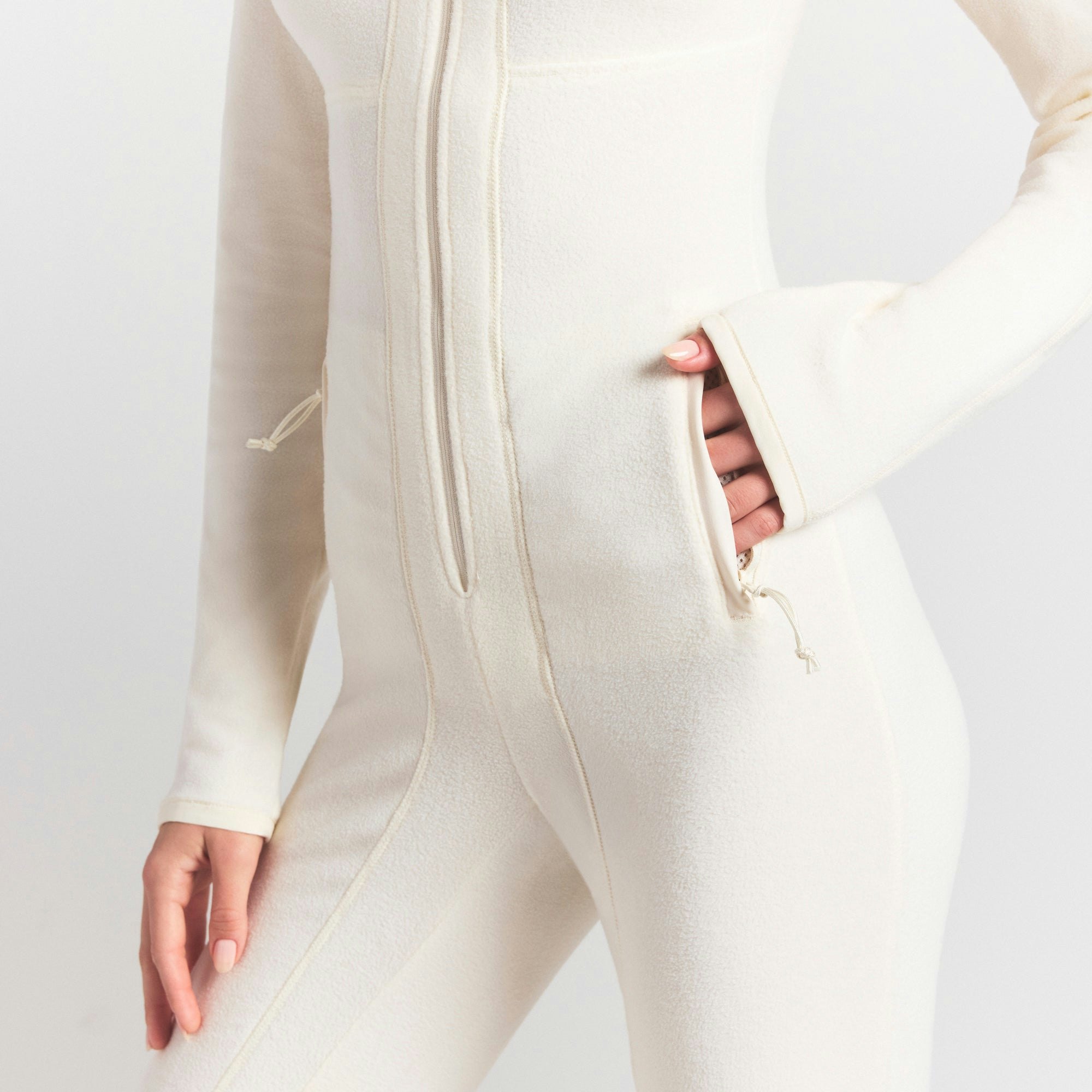 OUTDOOR FLEECE CATSUIT | ECRU ON A MODEL SIDE VIEW @ | FOCUS: 0.0, 1.0, 0.9