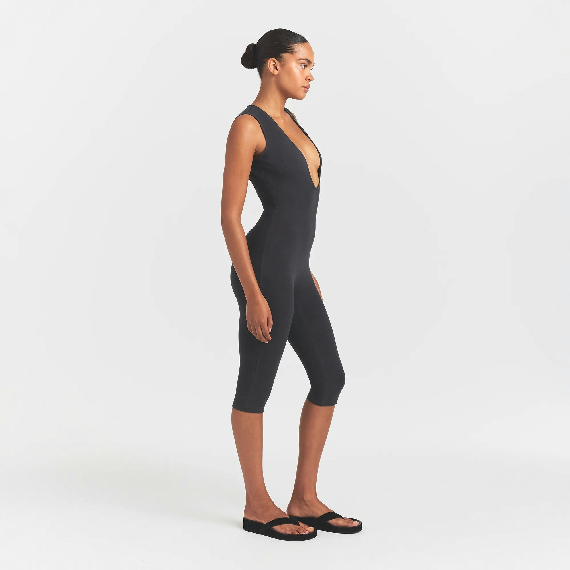 OUTDOOR DEEP PLUNGE ONESIE | WASHED ONYX ON A MODEL SIDEVIEW @ | FOCUS: 0.0, 1.0, 0.9 
