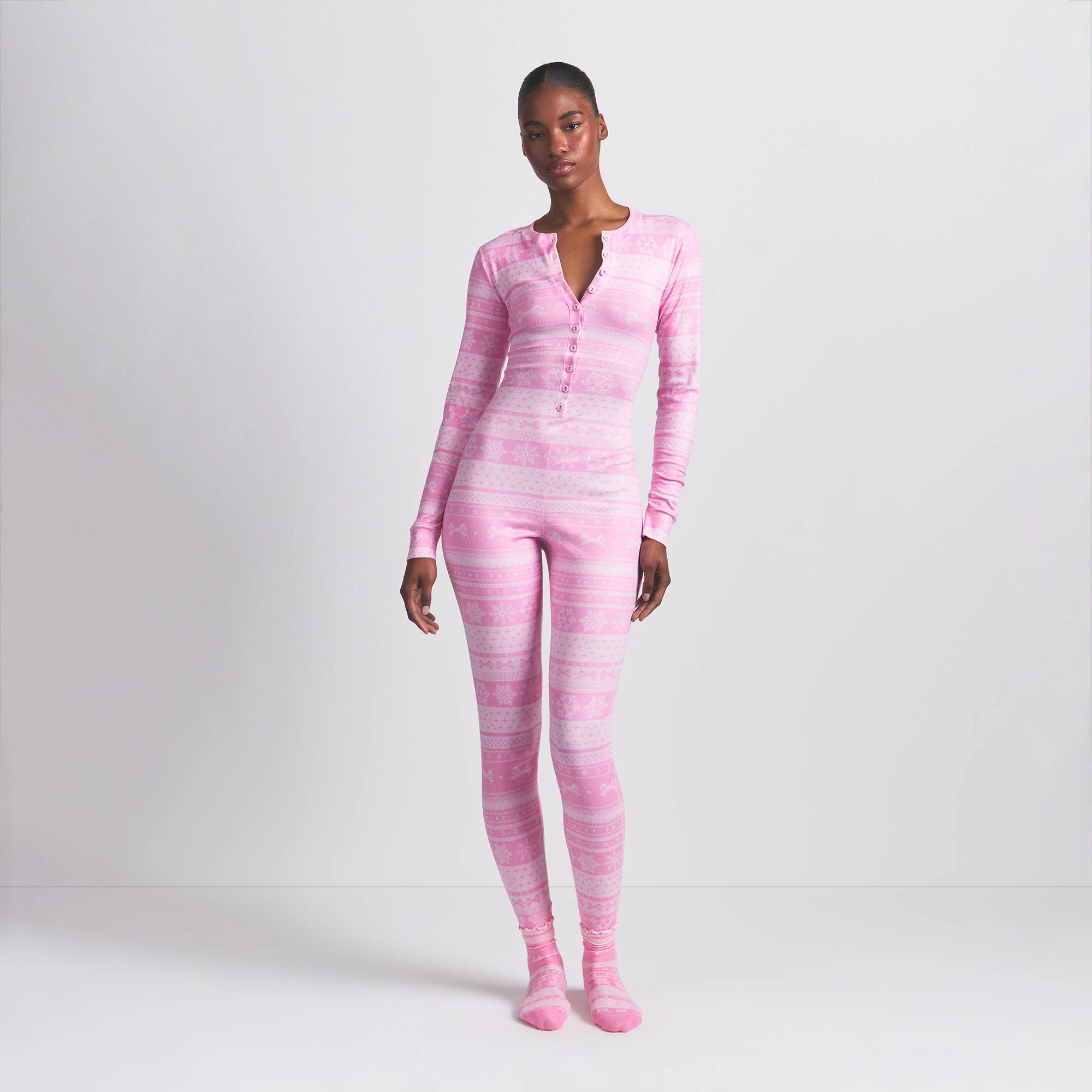 LOGO PLUSH POINTELLE HENLEY ONESIE | BUBBLE GUM BOW FAIR ISLE ON A MODEL FRONT VIEW @ | FOCUS: 0.0, 1.0, 0.9