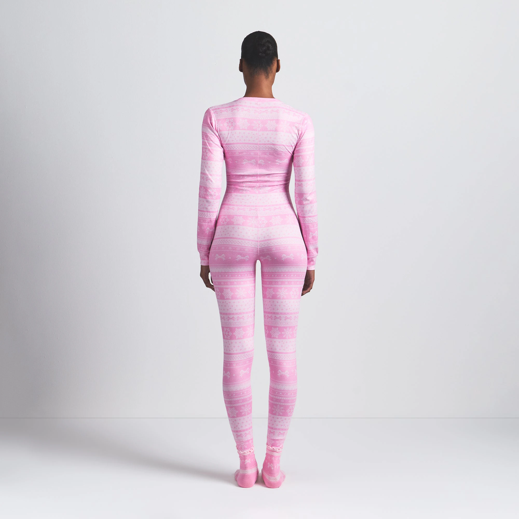 LOGO PLUSH POINTELLE HENLEY ONESIE | BUBBLE GUM BOW FAIR ISLE ON A MODEL BACK VIEW @ | FOCUS: 0.0, 1.0, 0.9