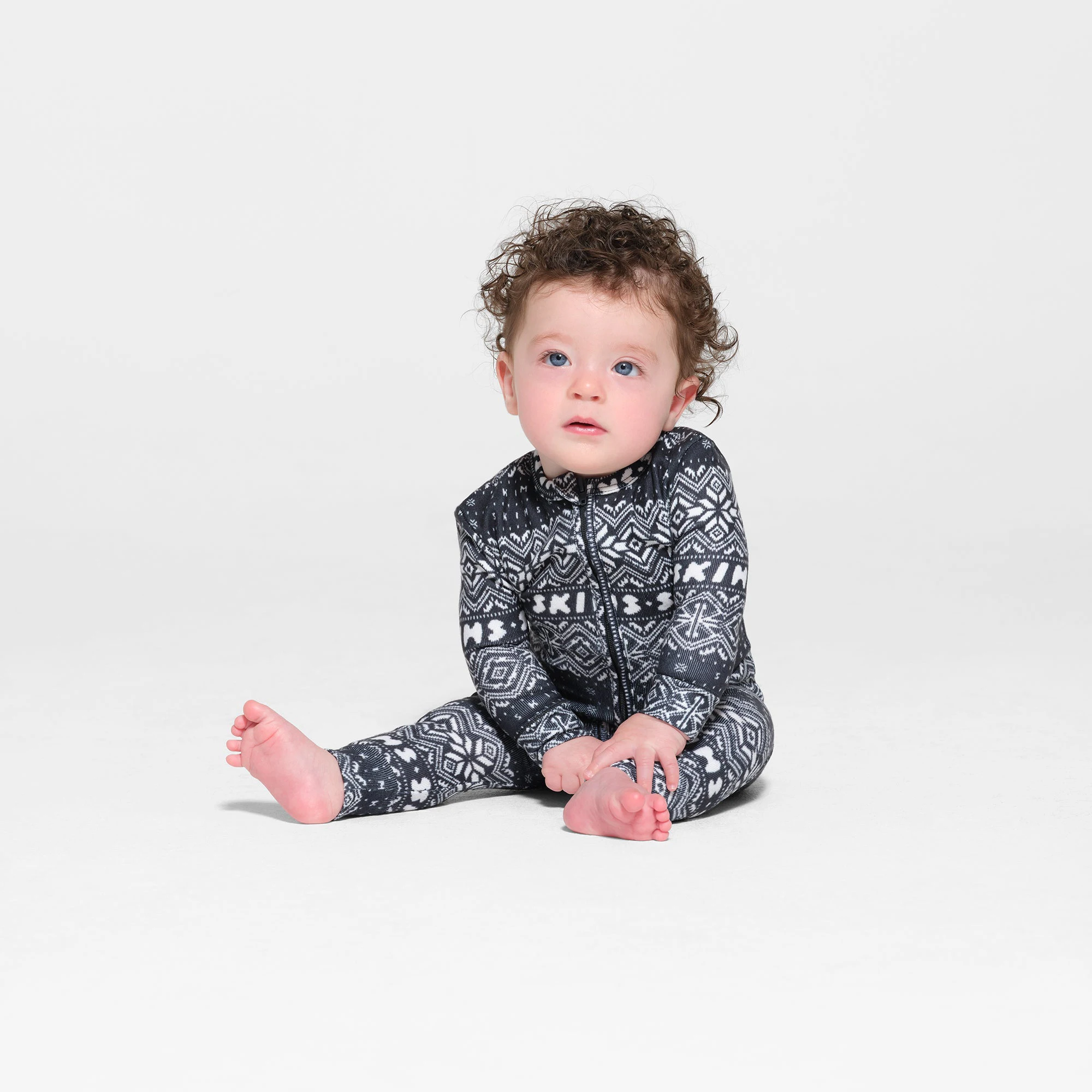 LOGO PLUSH POINTELLE BABY ONESIE | ONYX FAIR ISLE ON A MODEL FRONT VIEW