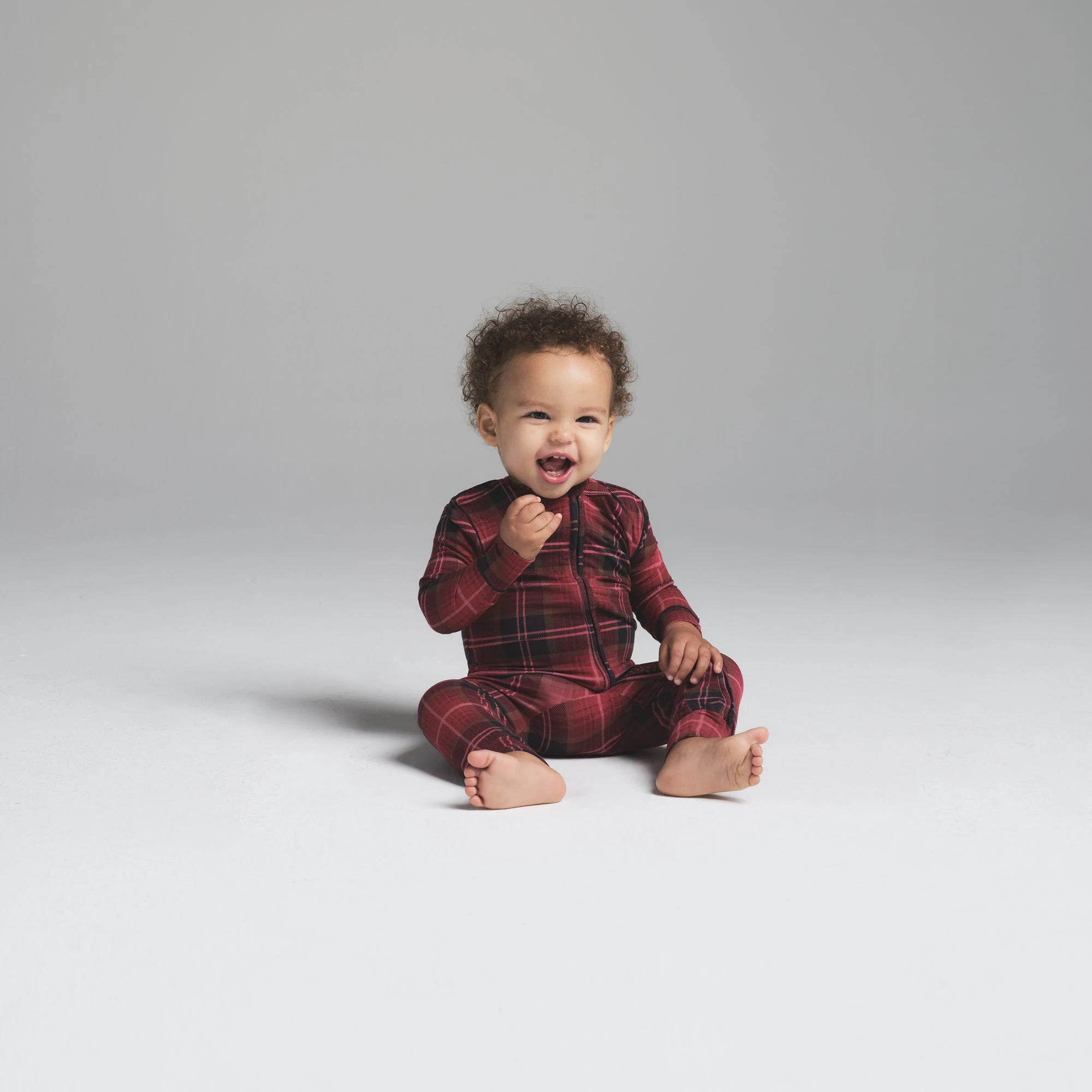 SKIMS SLEEP BABY ONESIE | CRANBERRY PLAID ON A MODEL FRONT VIEW
