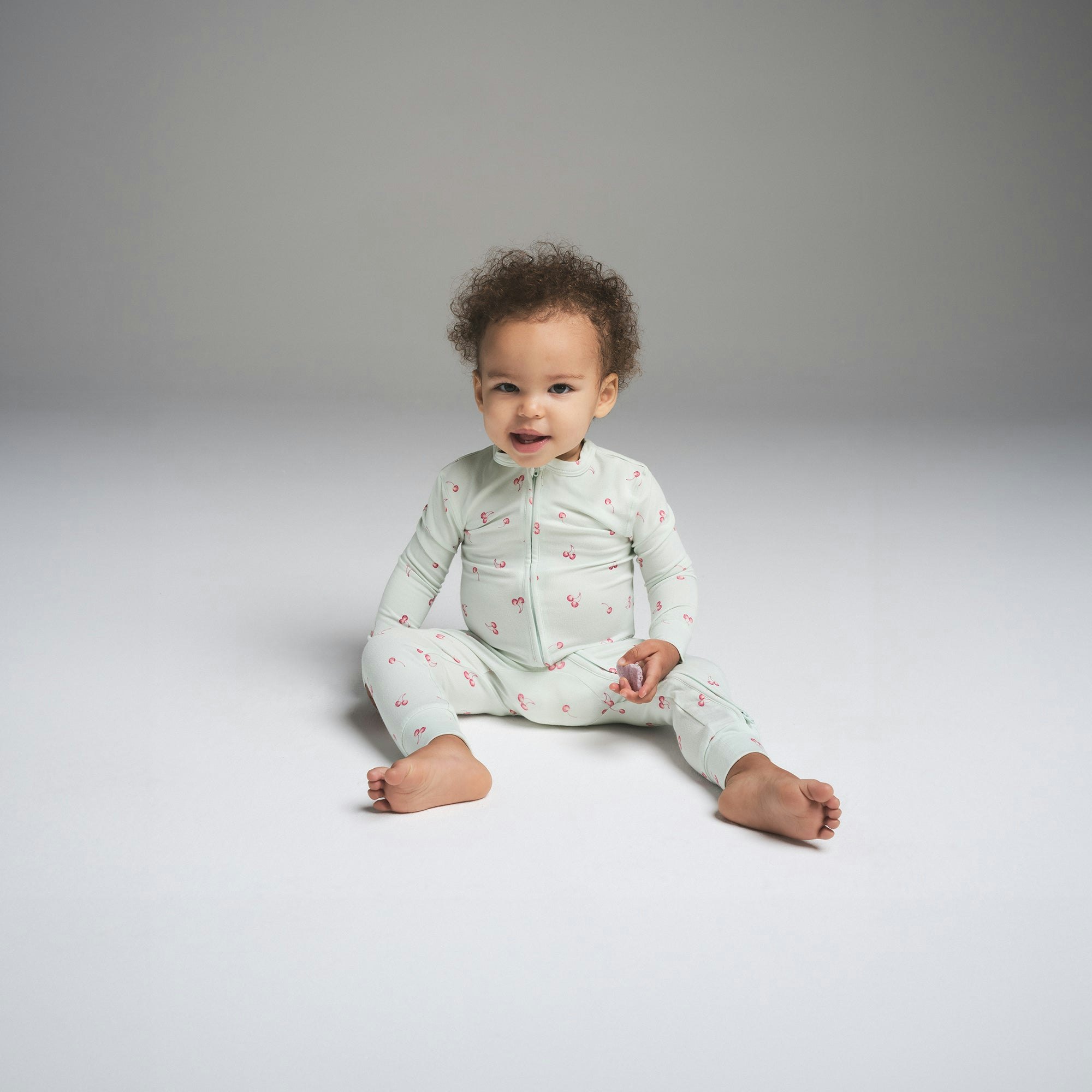 SKIMS SLEEP BABY ONESIE | CLOUD CHERRY PRINT ON A MODEL FRONT VIEW | FOCUS: 0.0, 1.0, 0.9