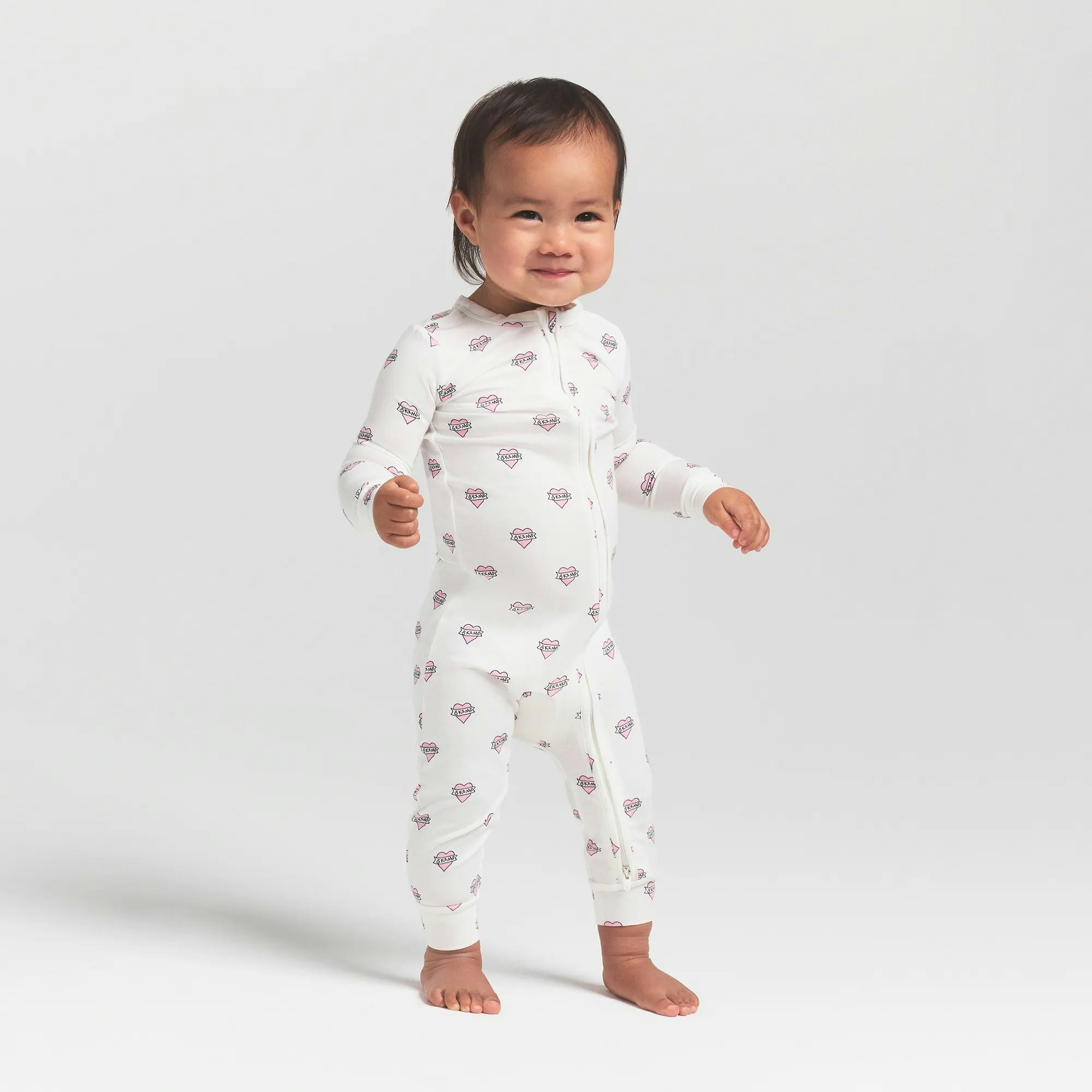 SKIMS SLEEP BABY ONESIE | MARBLE HEART BANNER ON A MODEL FRONT VIEW @ | FOCUS: 0.0, 1.0, 0.9