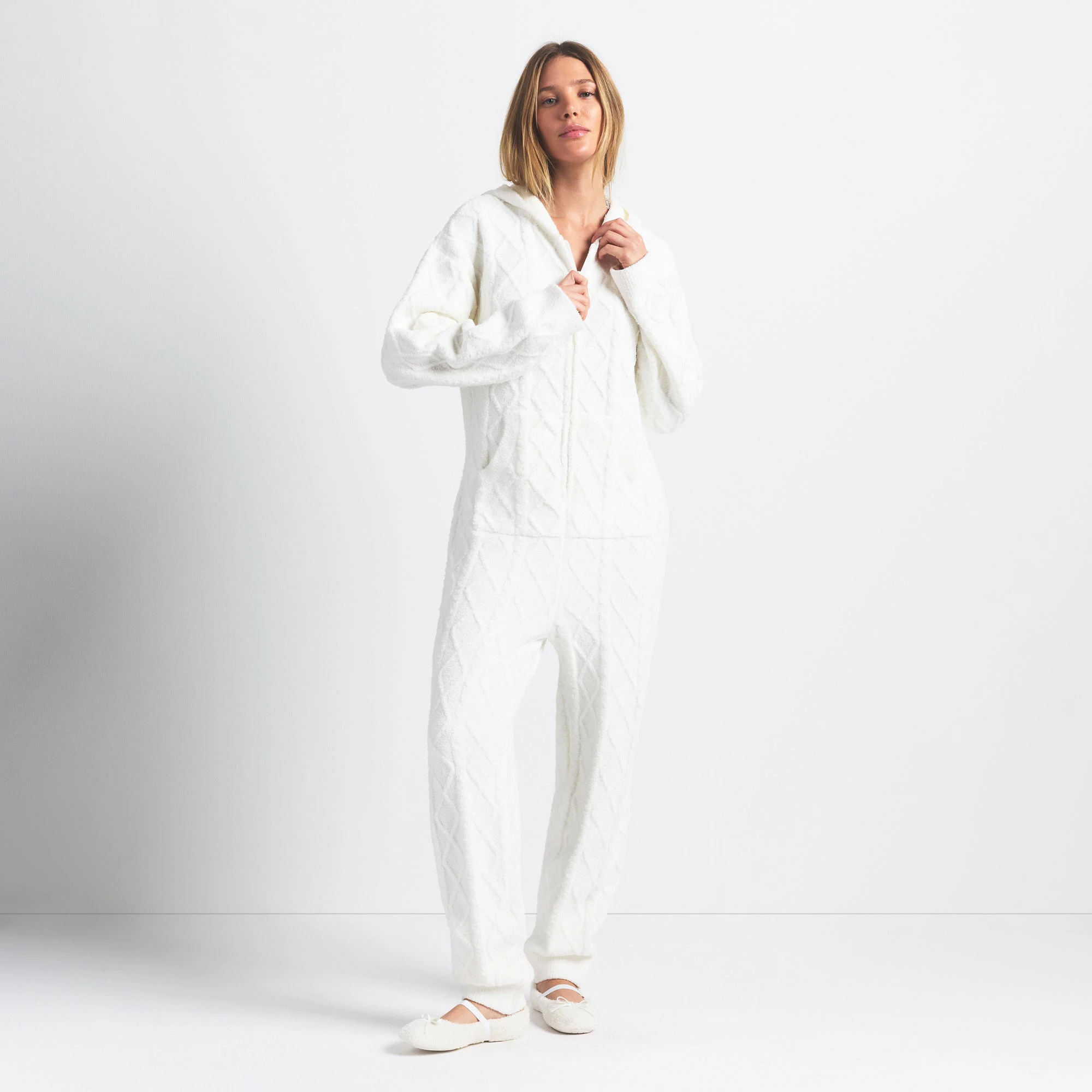 COZY LIGHT OVERSIZED CABLEKNIT ONESIE | IVORY ON A MODEL FRONT VIEW @ | FOCUS: 0.0, 1.0, 0.9