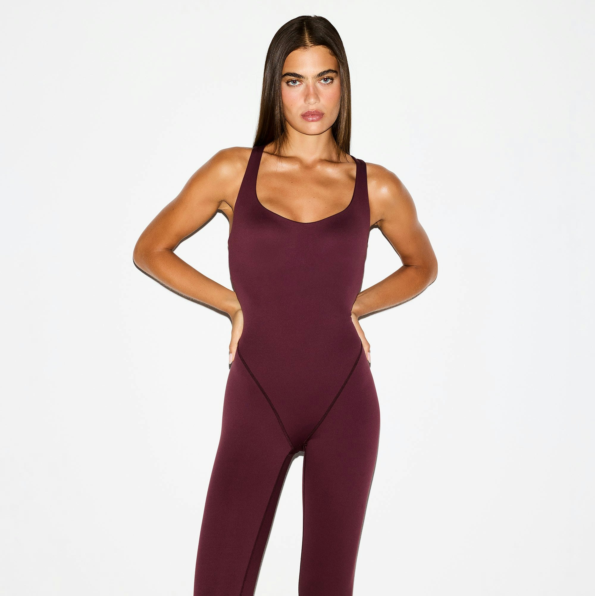 NikeSKIMS MATTE RACER LONG ONESIE | CURRANT ON A MODEL FRONT VIEW @ | FOCUS: 0.0, 1.0, 0.9