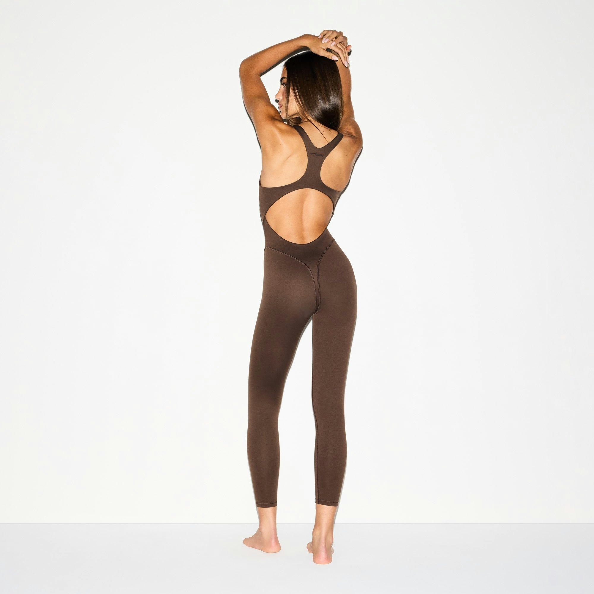NikeSKIMS MATTE RACER LONG ONESIE | DARK SEPIA ON A MODEL BACK VIEW @ | FOCUS: 0.0, 1.0, 0.9
