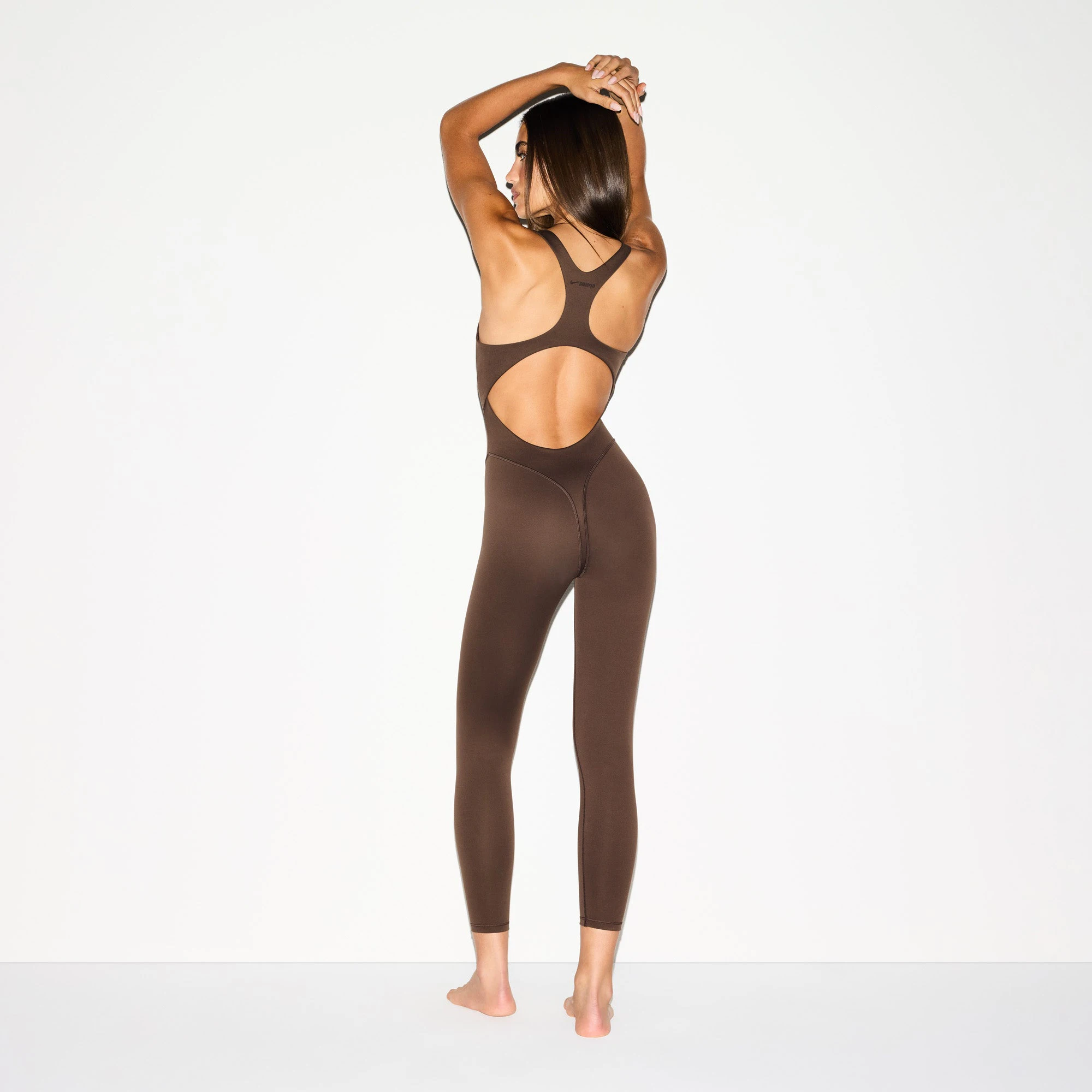 NikeSKIMS MATTE RACER LONG ONESIE | DARK SEPIA ON A MODEL BACK VIEW @ | FOCUS: 0.0, 1.0, 0.9