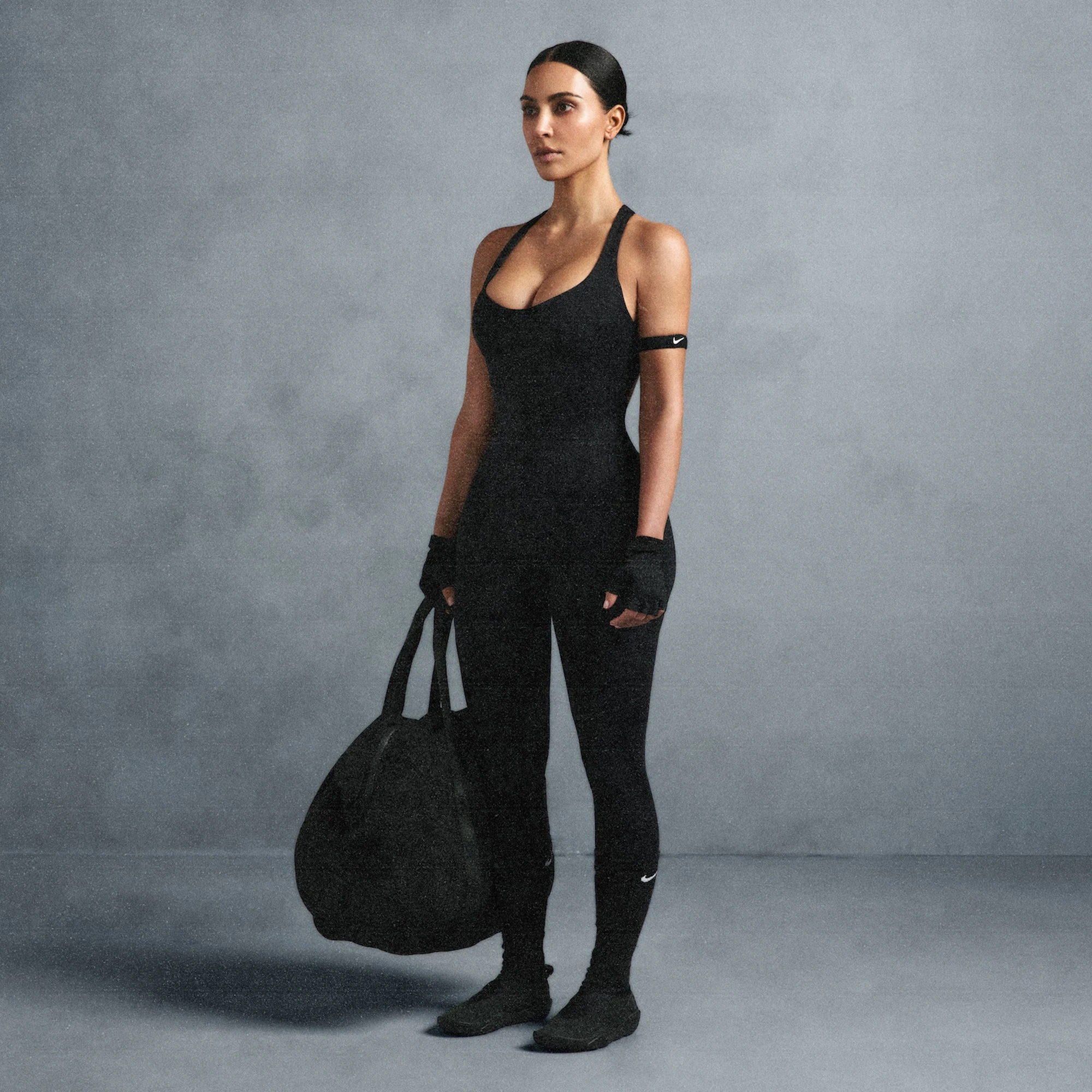 NikeSKIMS MATTE RACER LONG ONESIE | OBSIDIAN ON A MODEL SIDE VIEW @ | FOCUS: 0.0, 1.0, 0.9