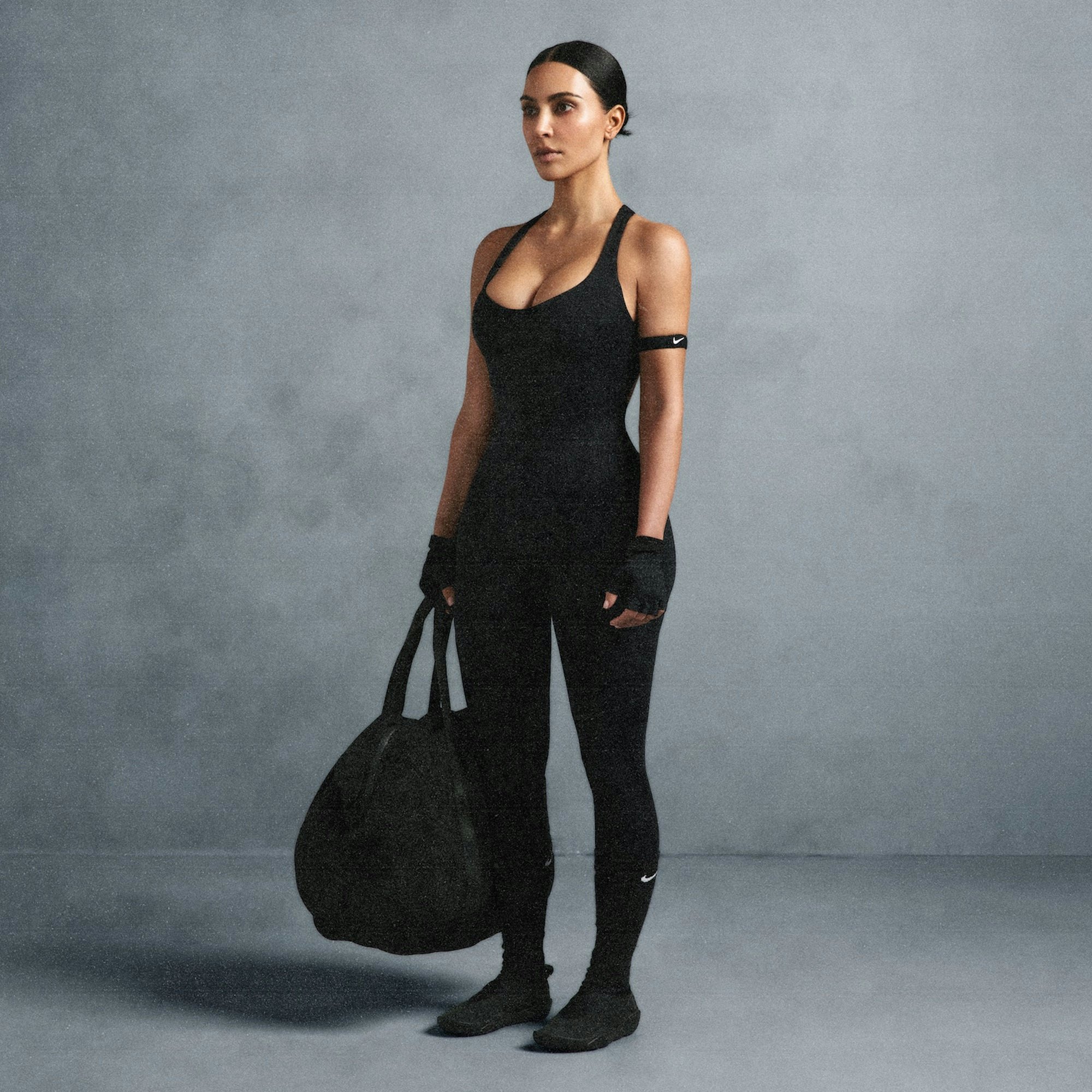 NikeSKIMS MATTE RACER LONG ONESIE | OBSIDIAN ON A MODEL SIDE VIEW @ | FOCUS: 0.0, 1.0, 0.9