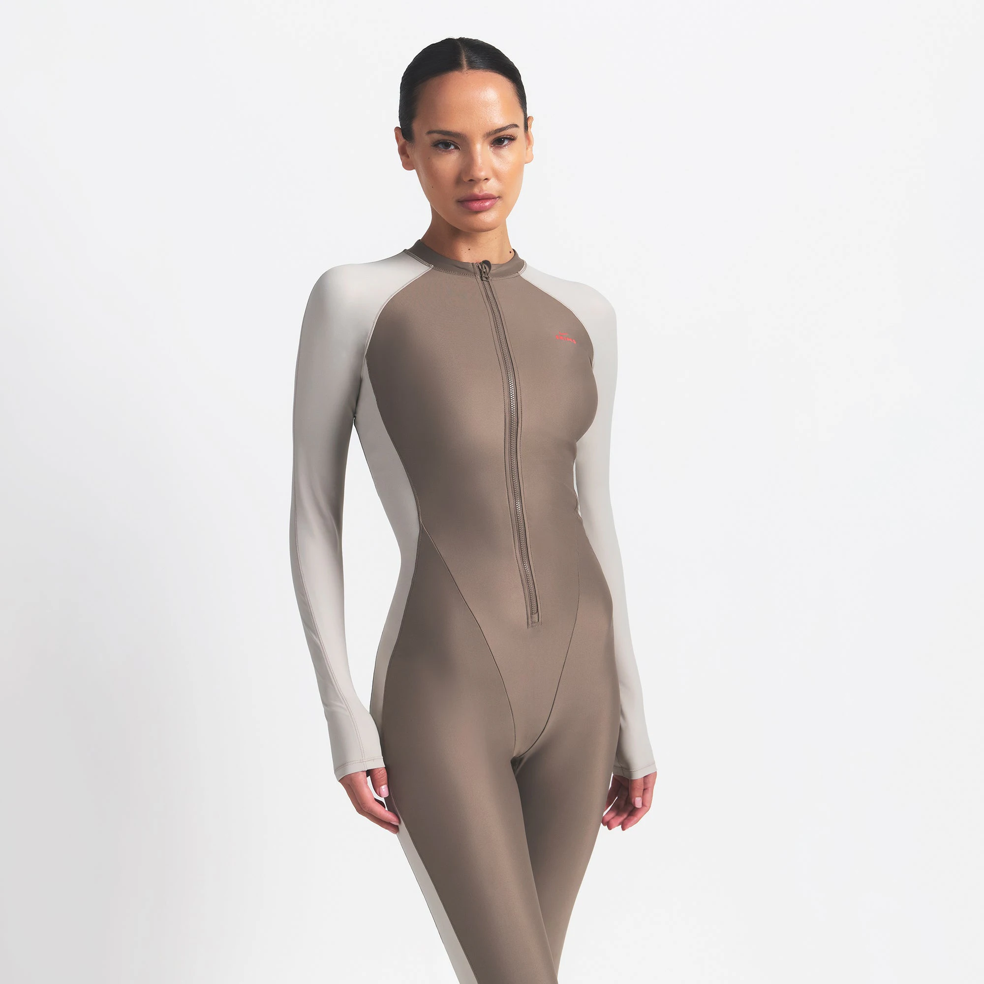 NikeSKIMS SHINE ZIP FRONT LONG ONESIE | TRUFFLE AND STONE ON A MODEL FRONT VIEW @ | FOCUS: 0.0, 1.0, 0.9