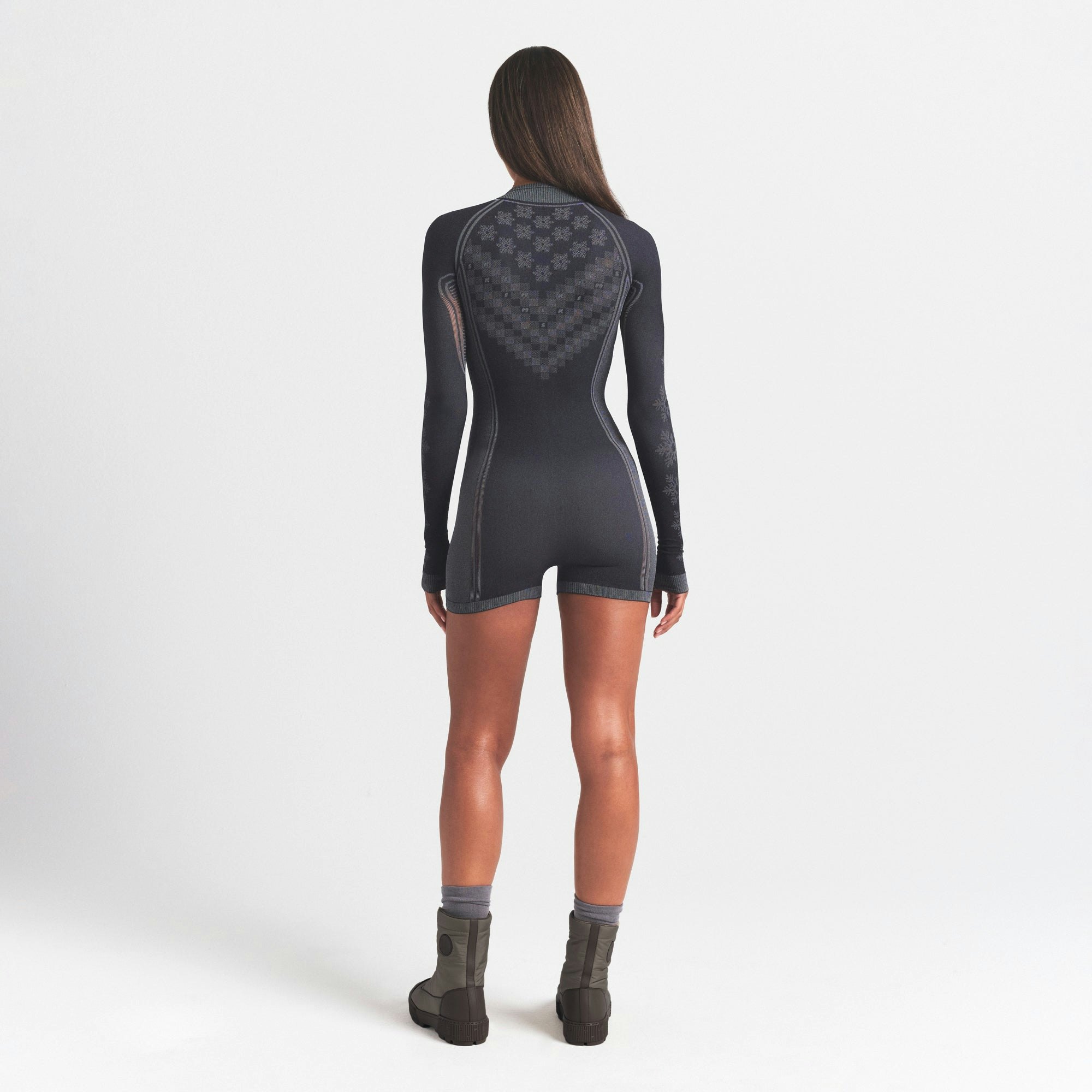 SKIMS FIRST LAYERS HALF ZIP ONESIE | OBSIDIAN WINTER FAIR ISLE ON A MODEL SIDE VIEW @ | FOCUS: 0.0, 1.0, 0.9