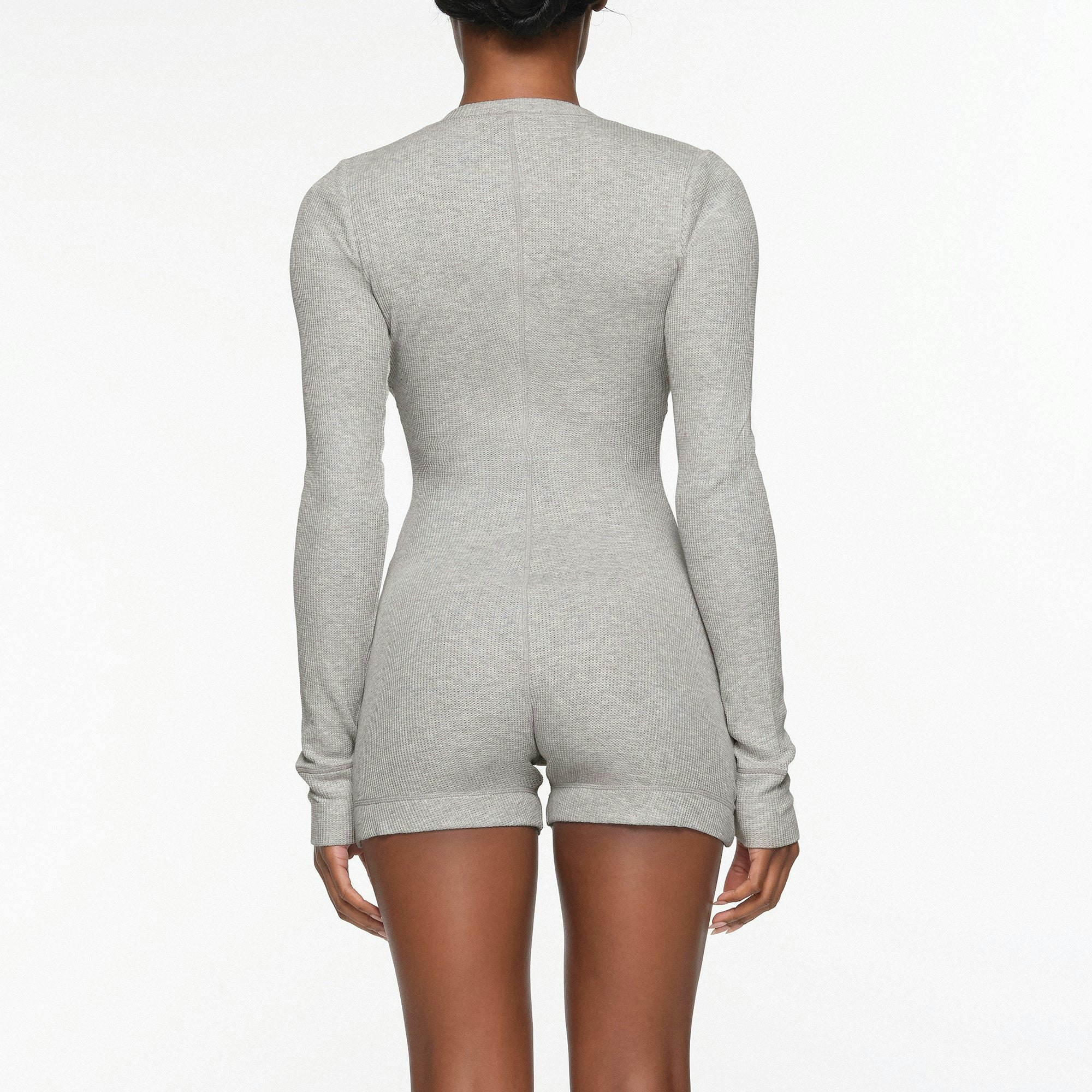 WAFFLE BUTTON UP HENLEY ONESIE WORN BY A MODEL IN BACK VIEW