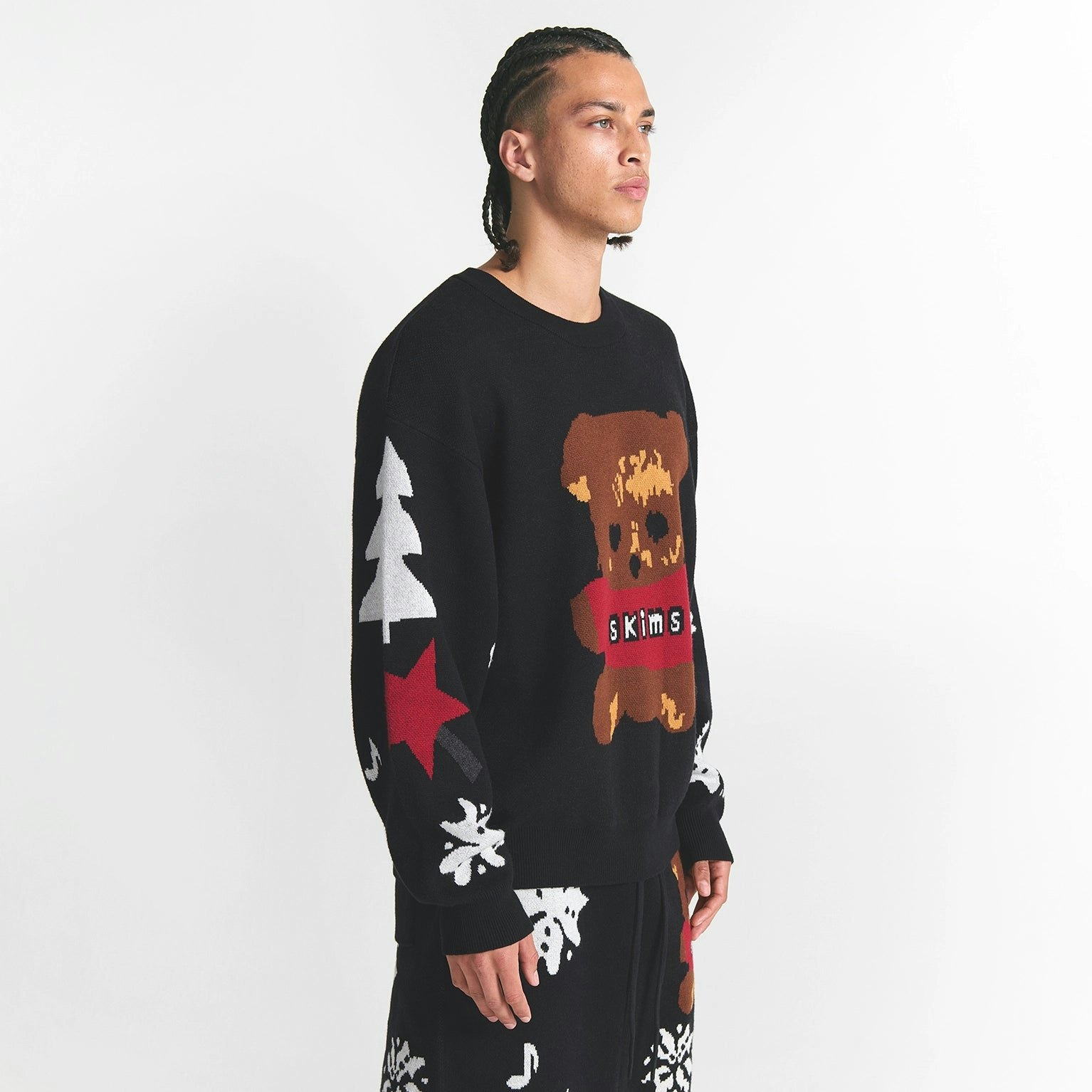 CACTUS PLANT FLEA MARKET X SKIMS COTTON KNIT MENS INTARSIA SWEATER | ONYX TEDDY BEAR SNOW PRINT ON A MODEL SIDE VIEW @ | FOCUS: 0.0, 1.0, 0.9