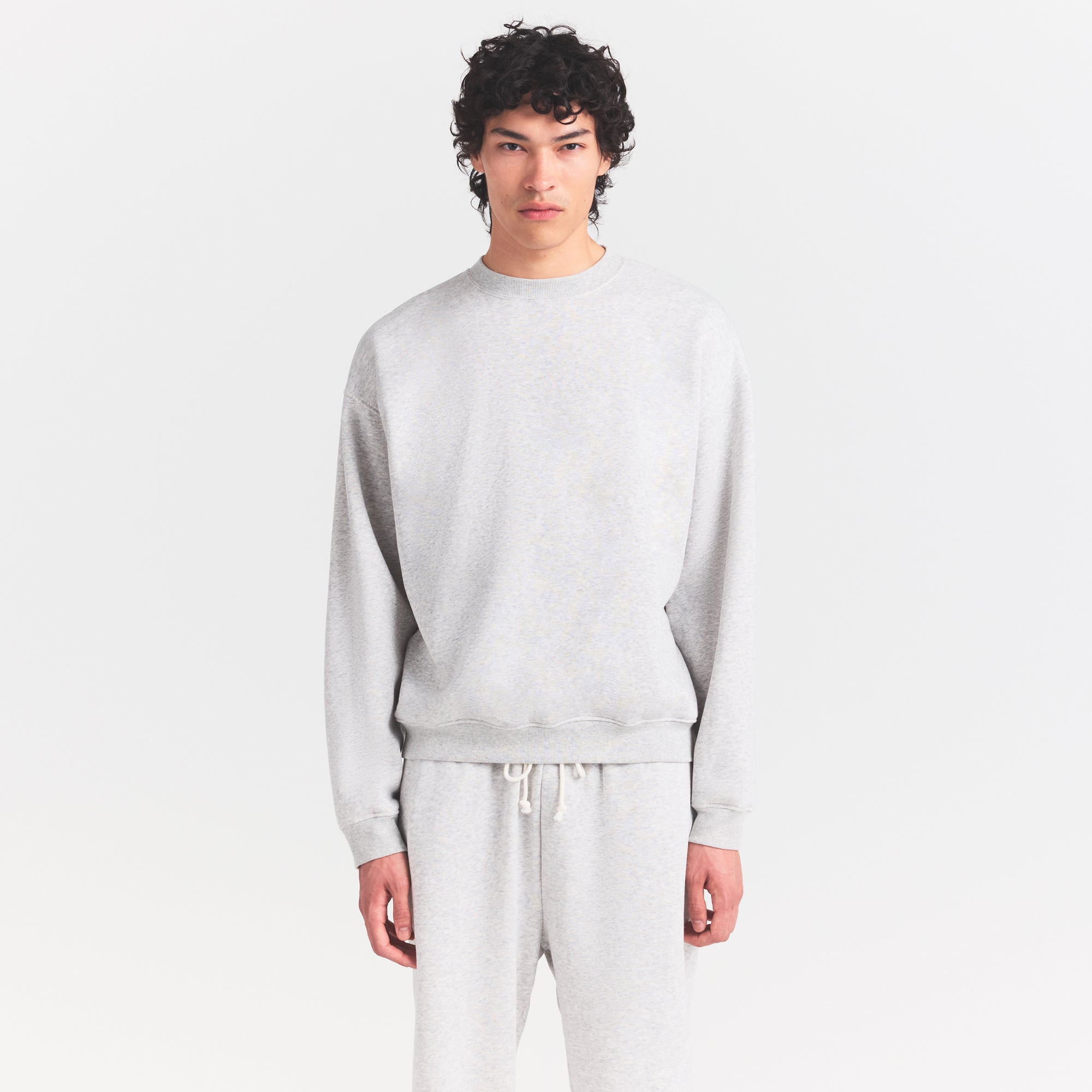 FLEECE LOUNGE MENS RELAXED HIGH CREWNECK | LIGHT HEATHER GREY ON A MODEL SIDE VIEW @ | FOCUS: 0.0, 1.0, 0.9