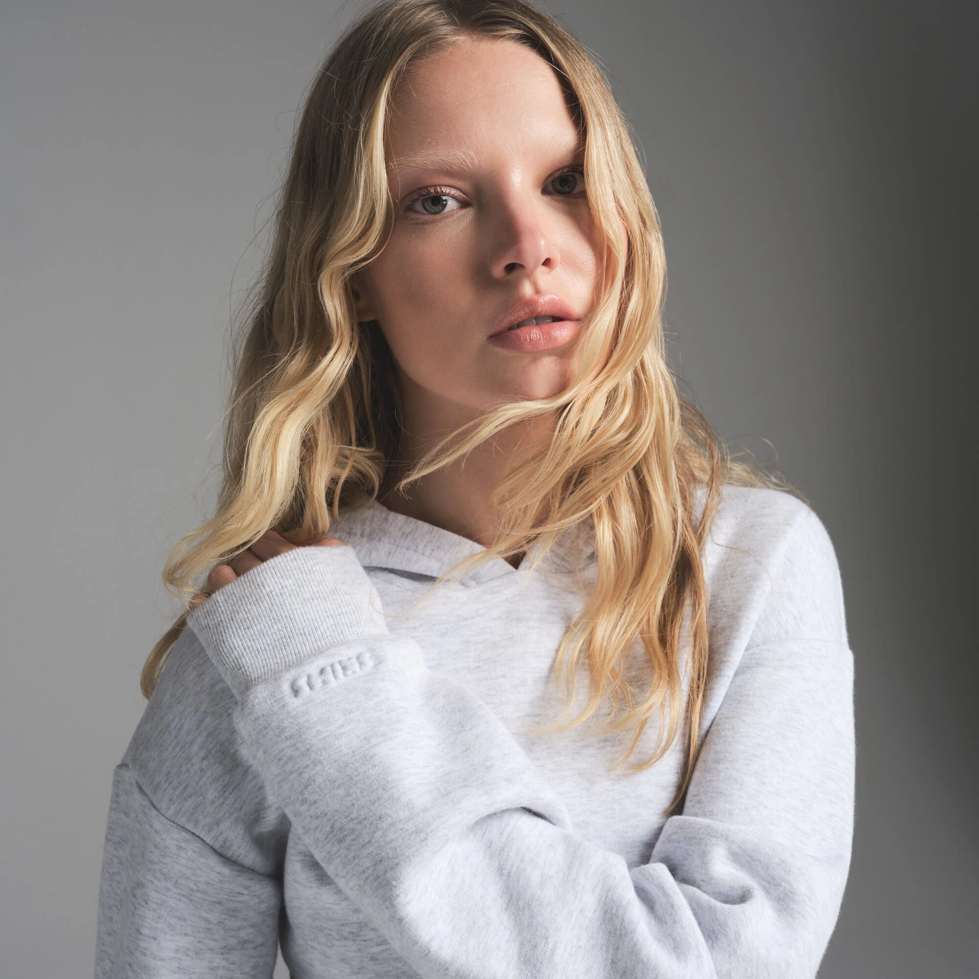 COTTON FLEECE SHRUNKEN HOODIE | LIGHT HEATHER GREY ON A MODEL FRONT VIEW | FOCUS: 0.0, 1.0, 0.9