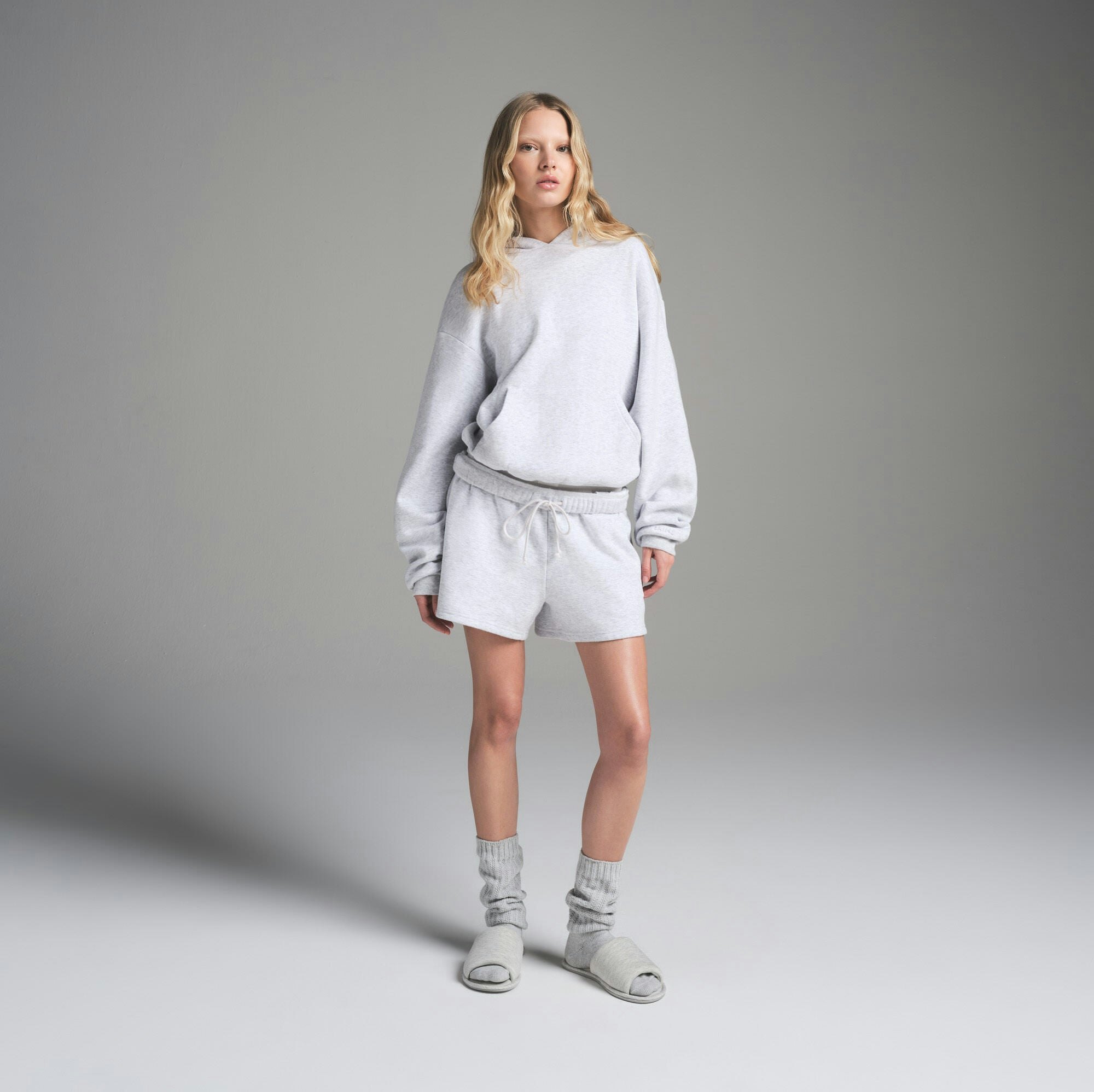 COTTON FLEECE CLASSIC HOODIE | LIGHT HEATHER GREY ON A MODEL FRONT VIEW | FOCUS: 0.0, 1.0, 0.9