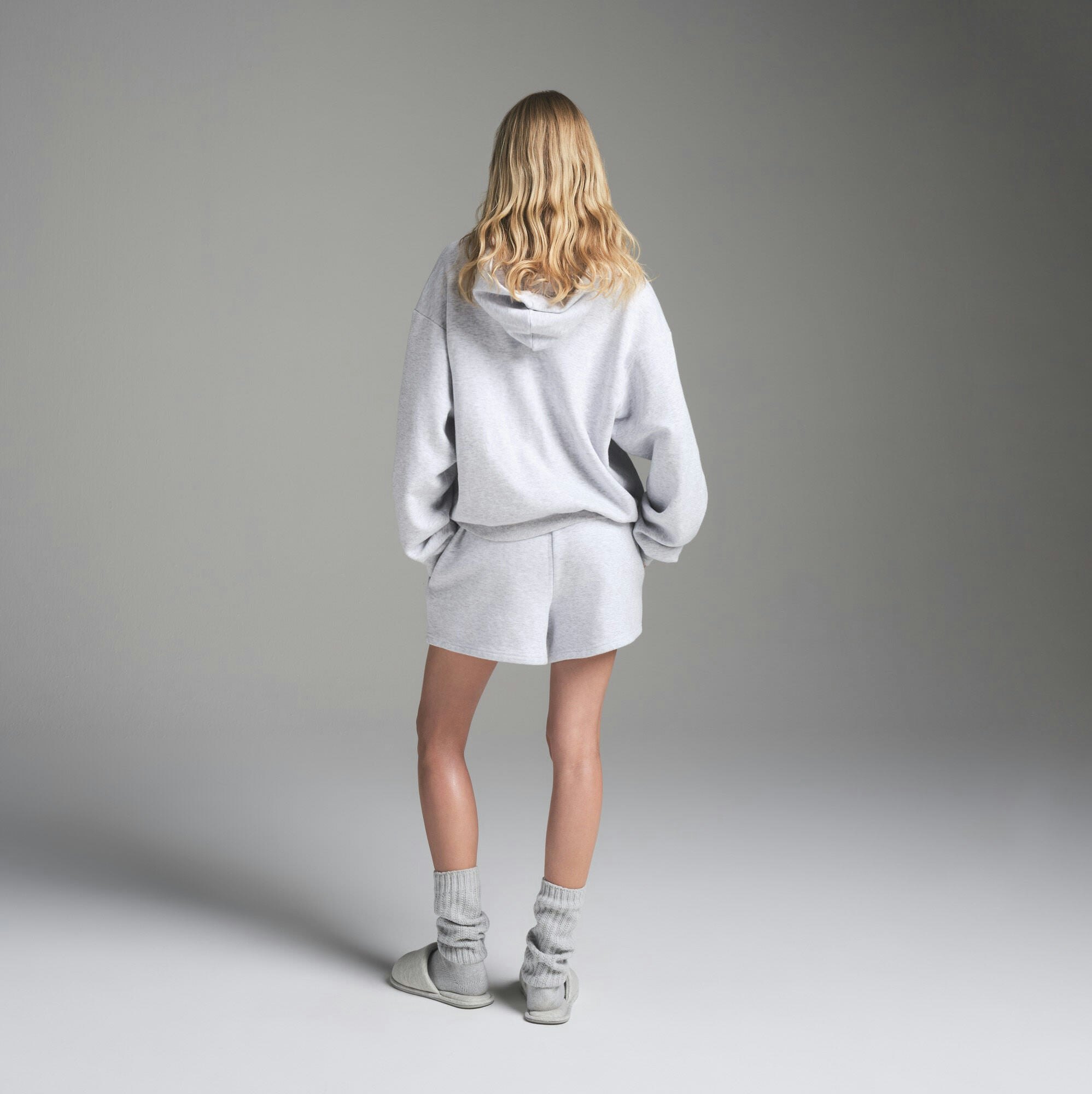 COTTON FLEECE CLASSIC HOODIE | LIGHT HEATHER GREY ON A MODEL FRONT VIEW | FOCUS: 0.0, 1.0, 0.9