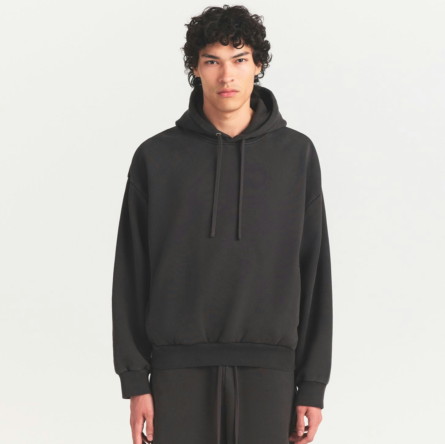 HEAVYWEIGHT FLEECE MENS HOODIE | WASHED ONYX ON A MODEL SIDE VIEW @ | FOCUS: 0.0, 1.0, 0.9