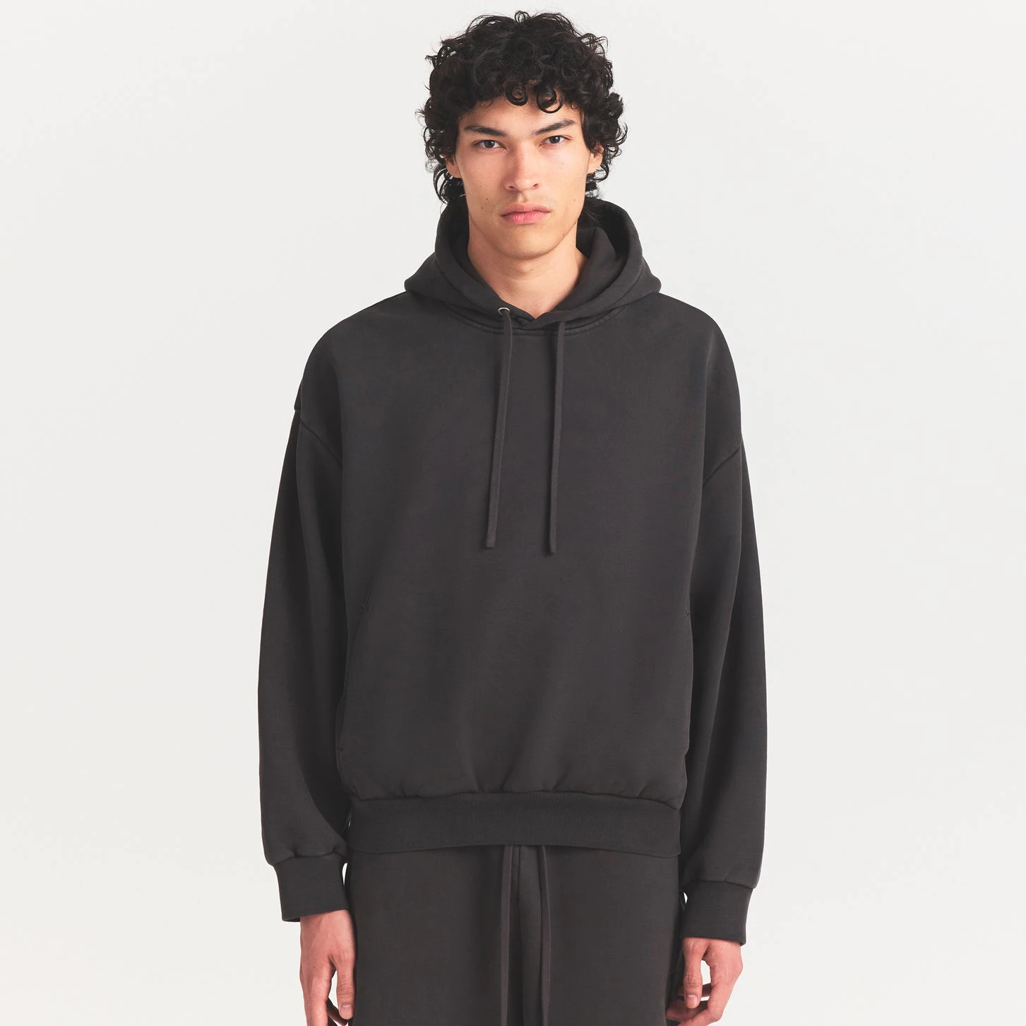 HEAVYWEIGHT FLEECE MENS HOODIE | WASHED ONYX ON A MODEL SIDE VIEW @ | FOCUS: 0.0, 1.0, 0.9