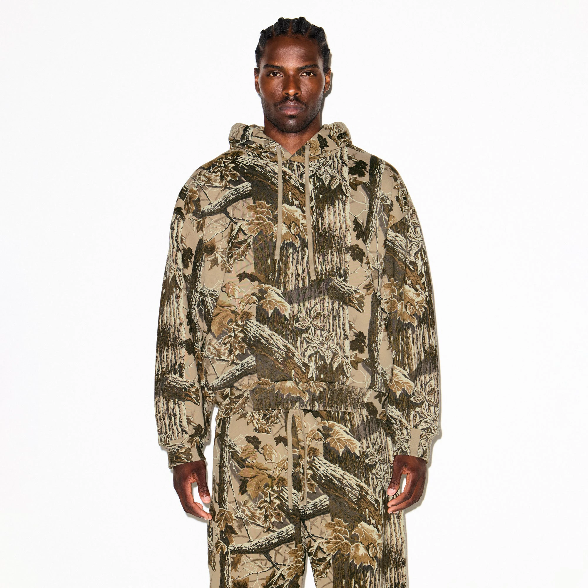 HEAVYWEIGHT FLEECE MENS RELAXED HOODIE | REALTREE CAMO PRINT ON A MODEL SIDE VIEW @ | FOCUS: 0.9, 0.1, 0.7