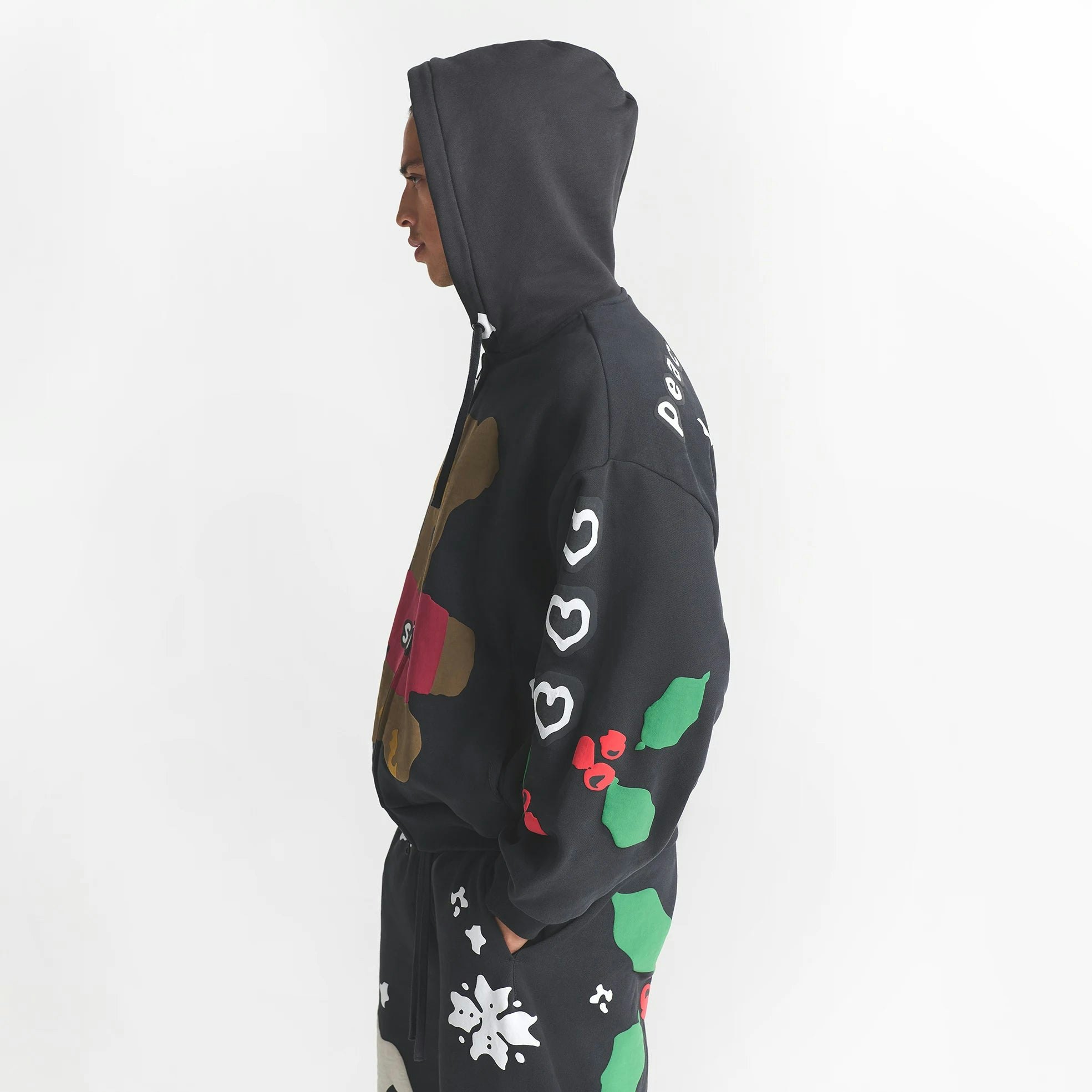 CACTUS PLANT FLEA MARKET X SKIMS HEAVYWEIGHT FLEECE MENS RELAXED ZIP UP HOODIE | ONYX TEDDY BEAR PRINT ON A MODEL SIDE VIEW @ | FOCUS: 0.0, 1.0, 0.9