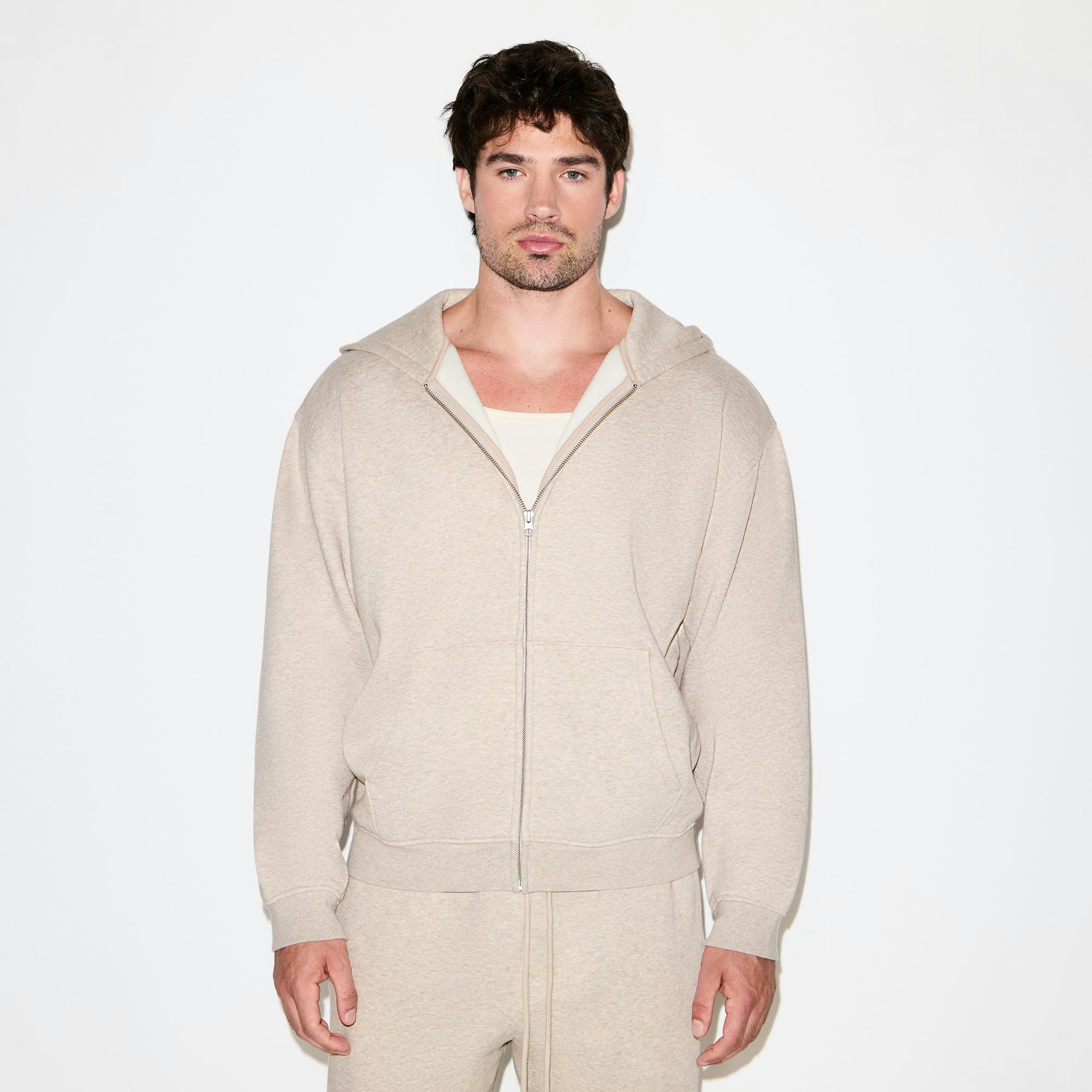 FLEECE LOUNGE MENS RELAXED ZIP UP HOODIE | DESERT HEATHER ON A MODEL SIDE VIEW @ | FOCUS: 0.0, 1.0, 0.9