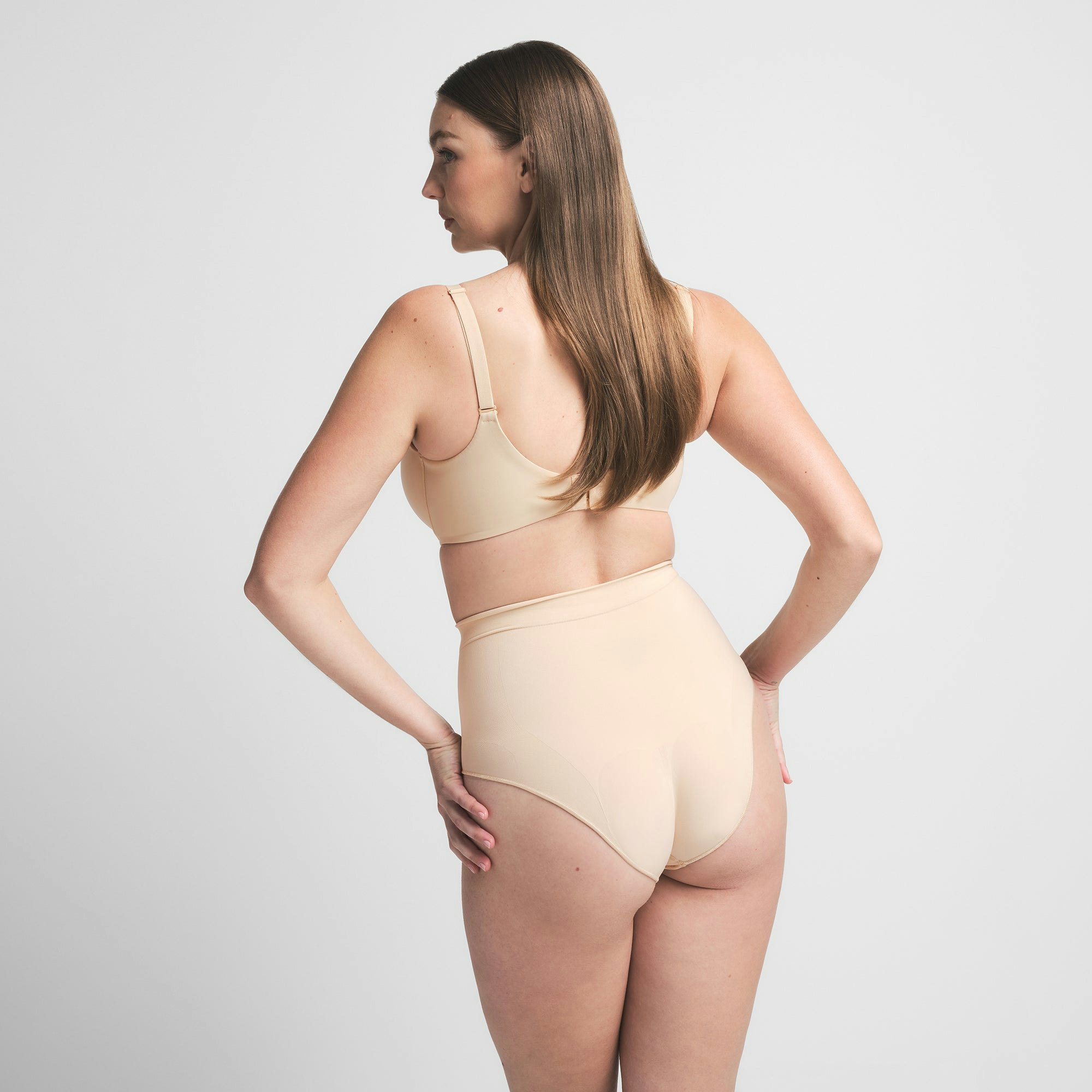 SEAMLESS SCULPT MID WAIST BRIEF | SAND ON A MODEL BACK VIEW | FOCUS: 0.0, 1.0, 0.9