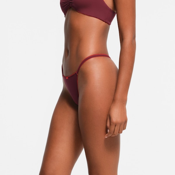 FITS EVERYBODY PICOT TRIM STRING THONG | WINE CONTRAST ON A MODEL SIDE VIEW