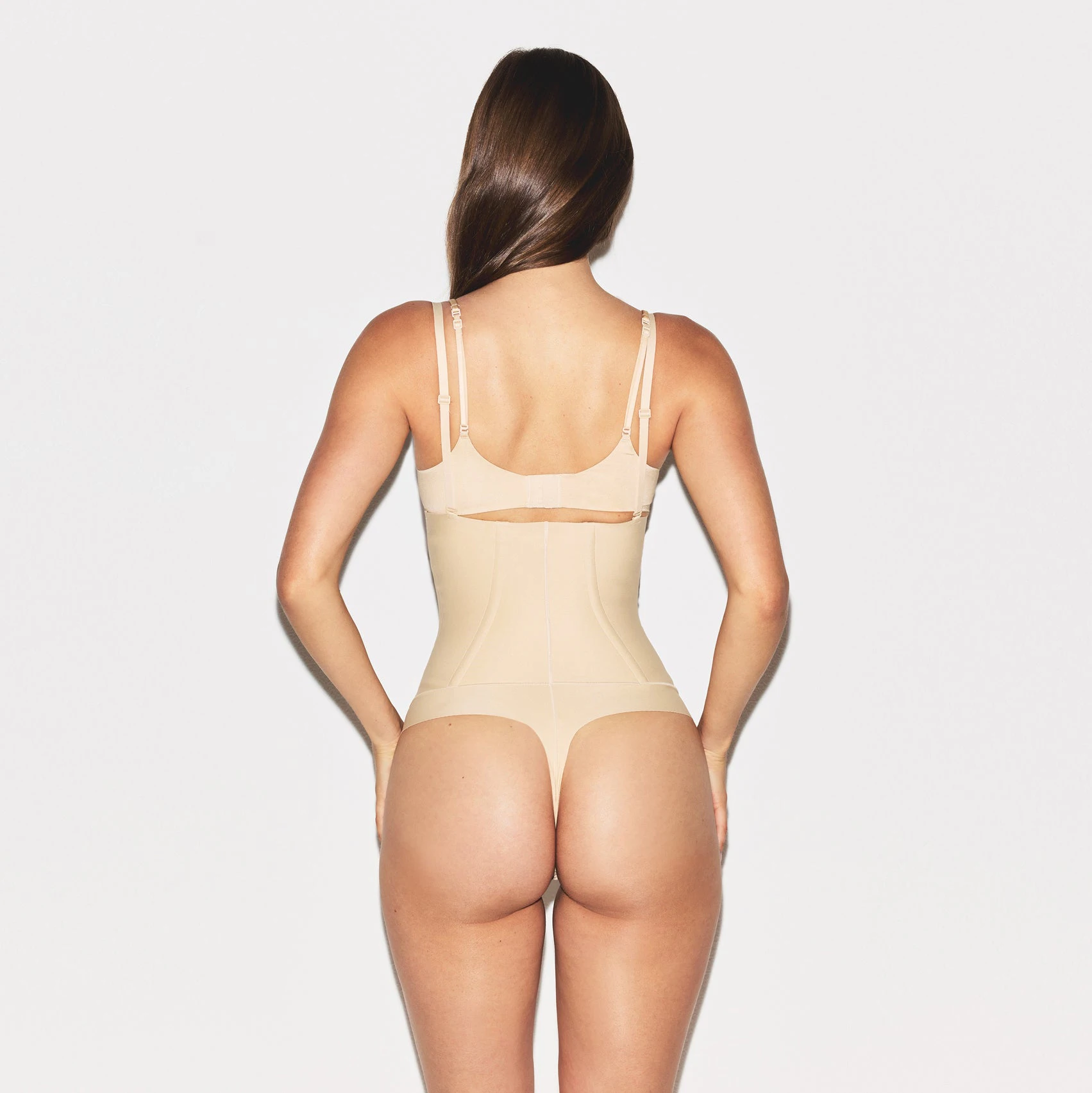 SKIMS BODY CORE SCULPT WAIST CINCHER THONG | SAND ON A MODEL SIDE VIEW @ | FOCUS: 0.0, 1.0, 0.9