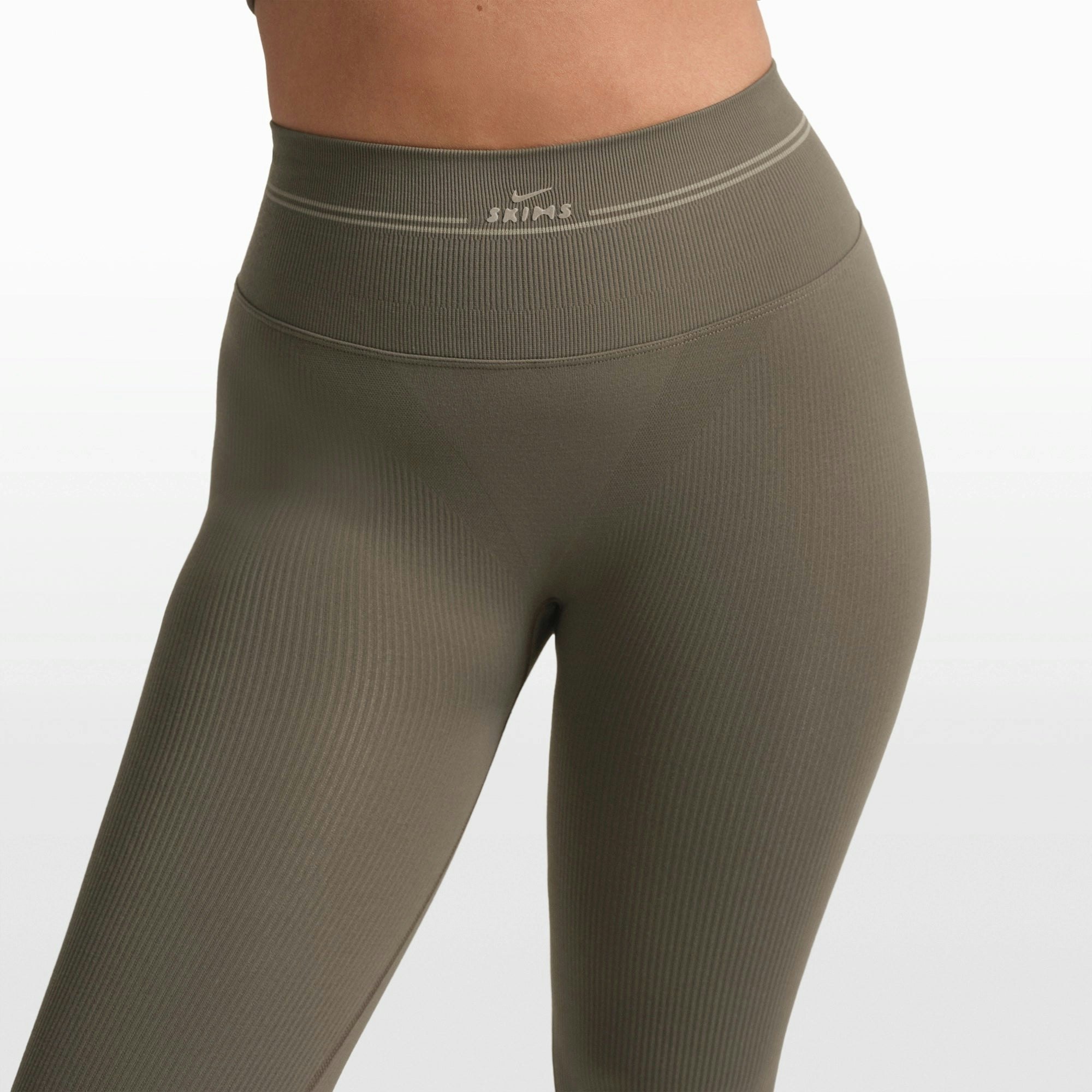 NikeSKIMS RIBBED SEAMLESS 26" LEGGING | DUSTY OAKMOSS/DUNE ON A MODEL FRONT VIEW @ | FOCUS: 0.0, 1.0, 0.9