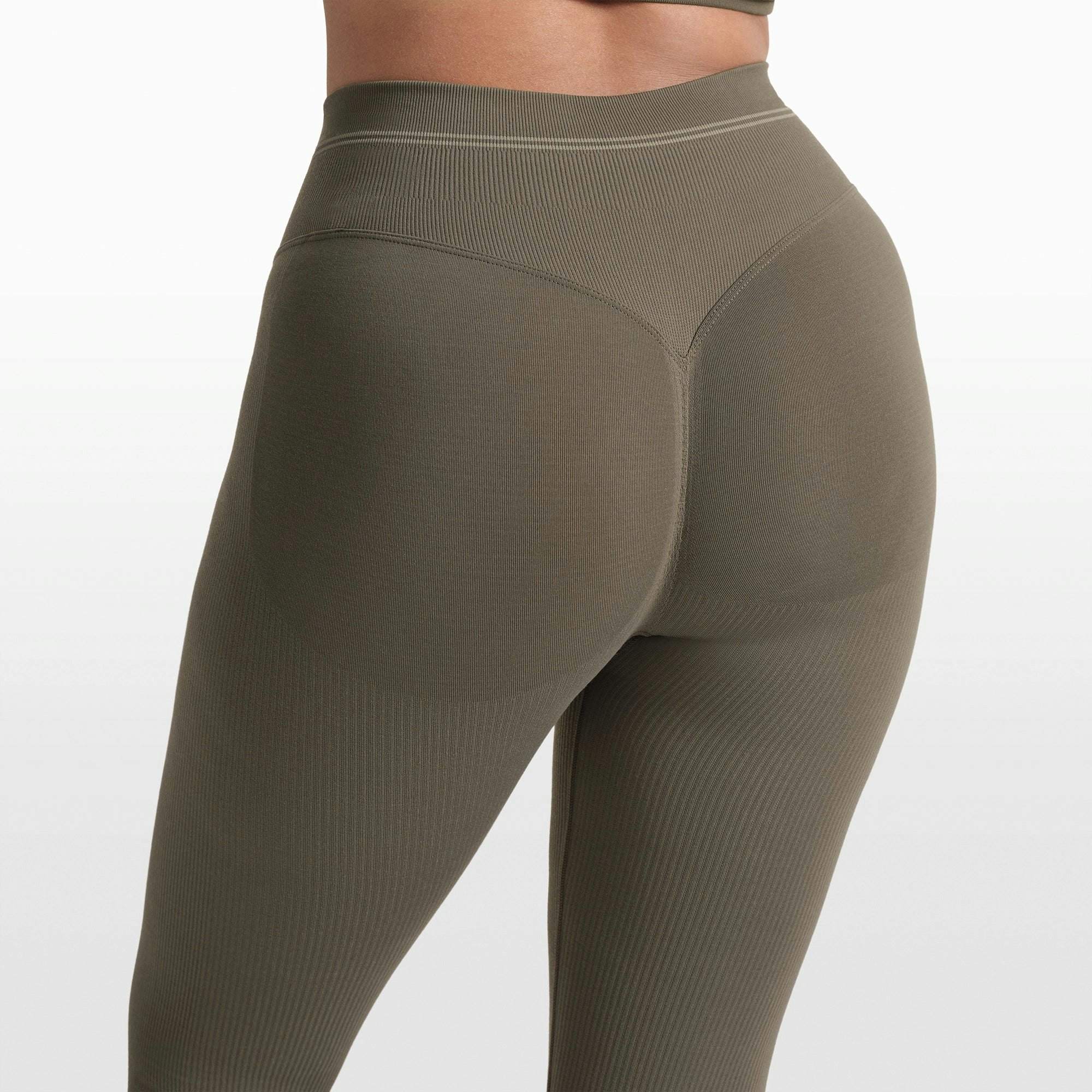 NikeSKIMS RIBBED SEAMLESS 26" LEGGING | DUSTY OAKMOSS/DUNE ON A MODEL FRONT VIEW @ | FOCUS: 0.0, 1.0, 0.9