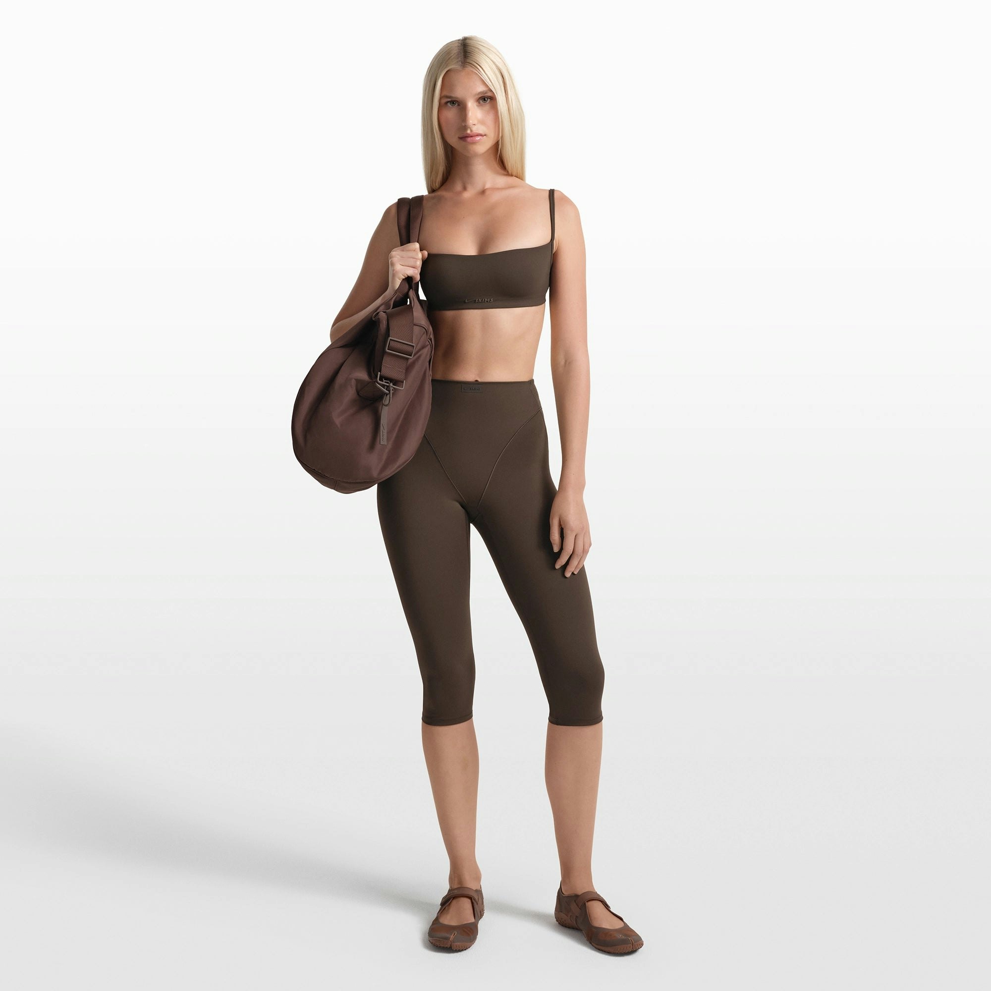 NikeSKIMS MATTE 17" V-LINE CROP LEGGING | DARK SEPIA ON A MODEL FRONT VIEW @ | FOCUS: 0.0, 1.0, 0.9