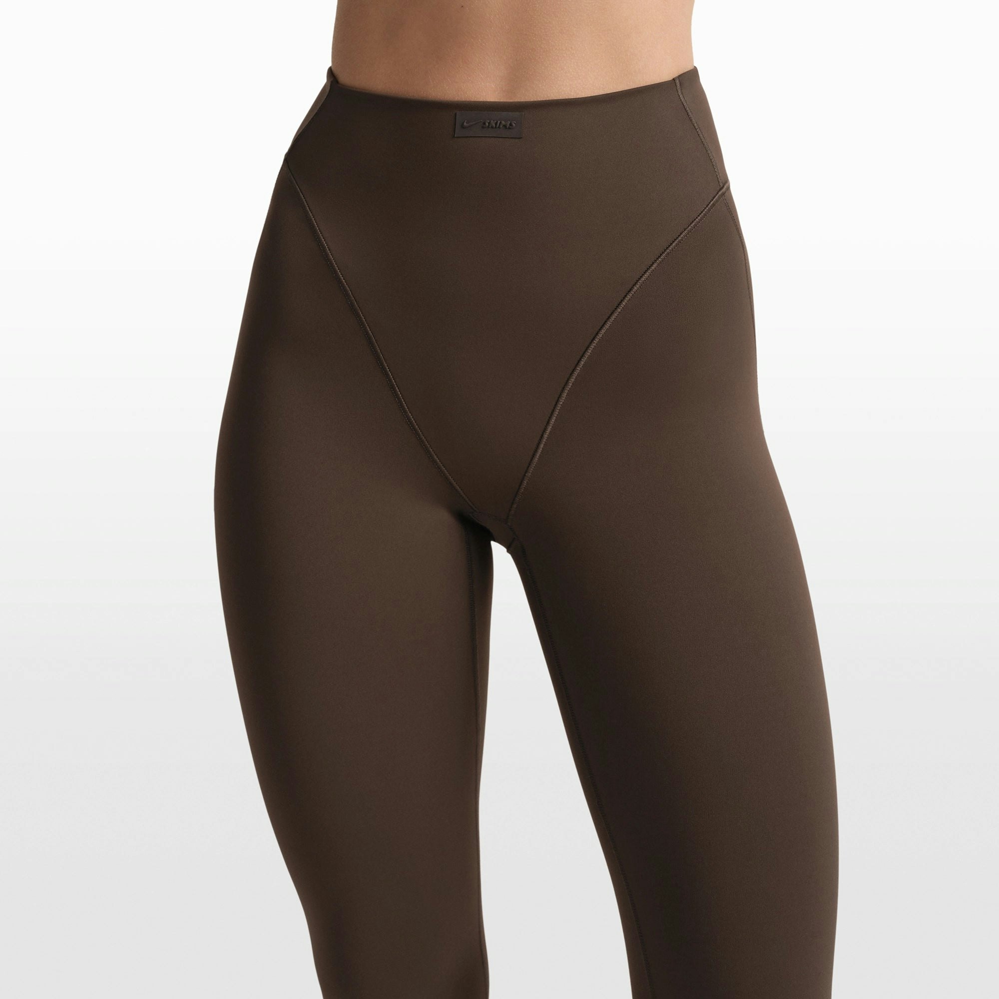 NikeSKIMS MATTE 17" V-LINE CROP LEGGING | DARK SEPIA ON A MODEL FRONT VIEW @ | FOCUS: 0.0, 1.0, 0.9